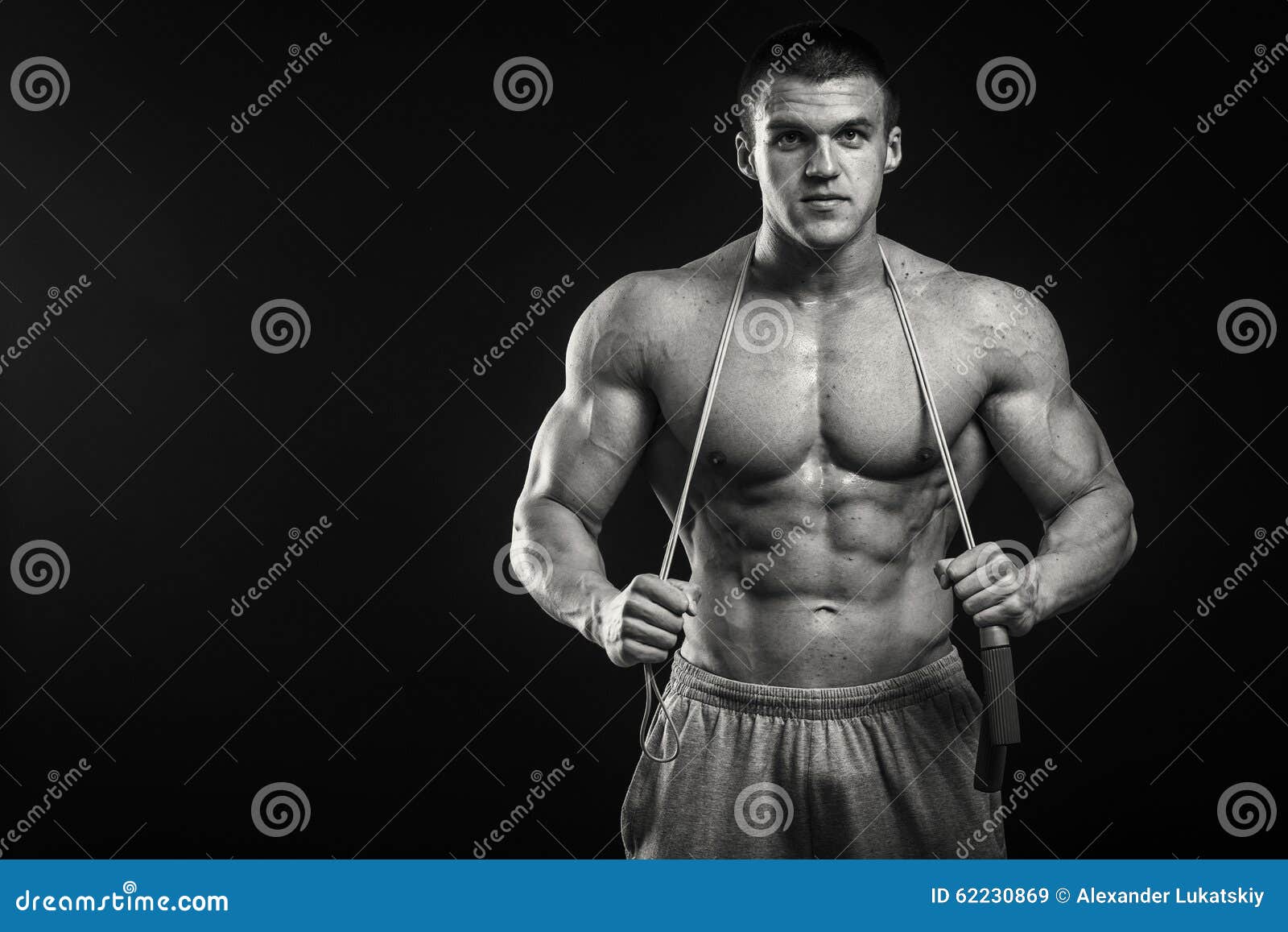 Muscular Athlete Demonstrates His Muscles Under Load on a Dark ...