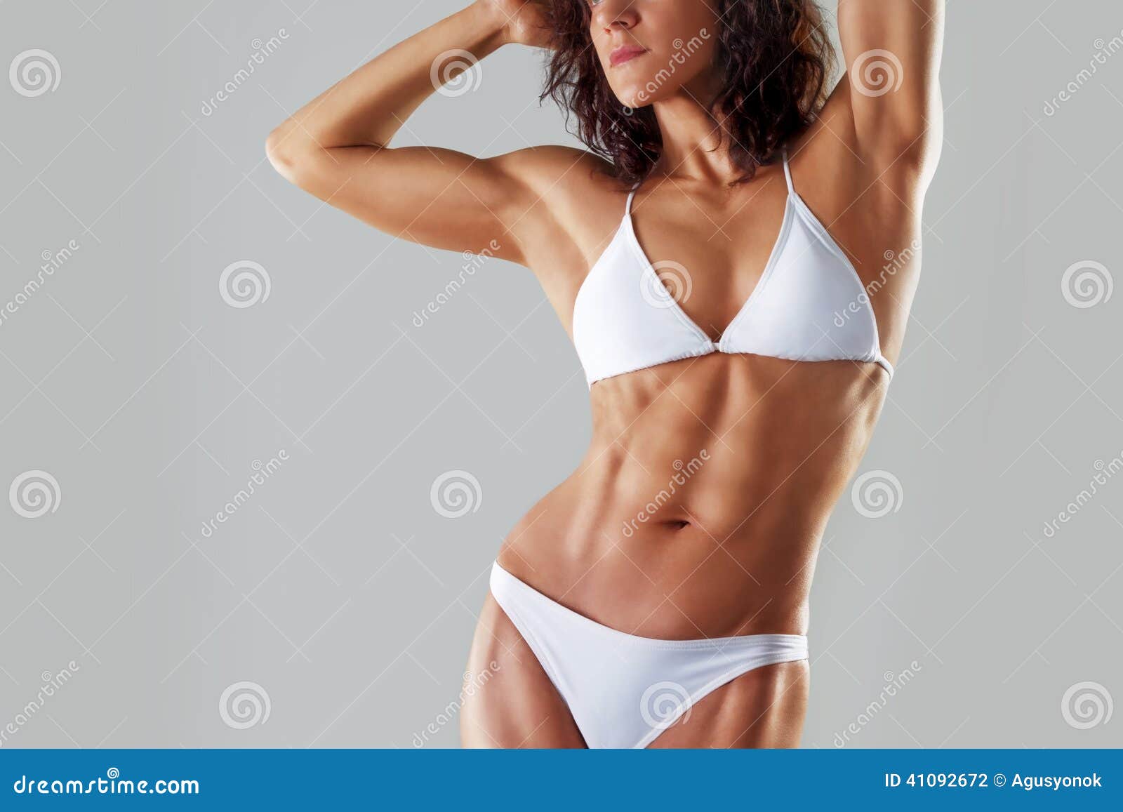 muscular athletic young woman in a white bathing suit . fitness