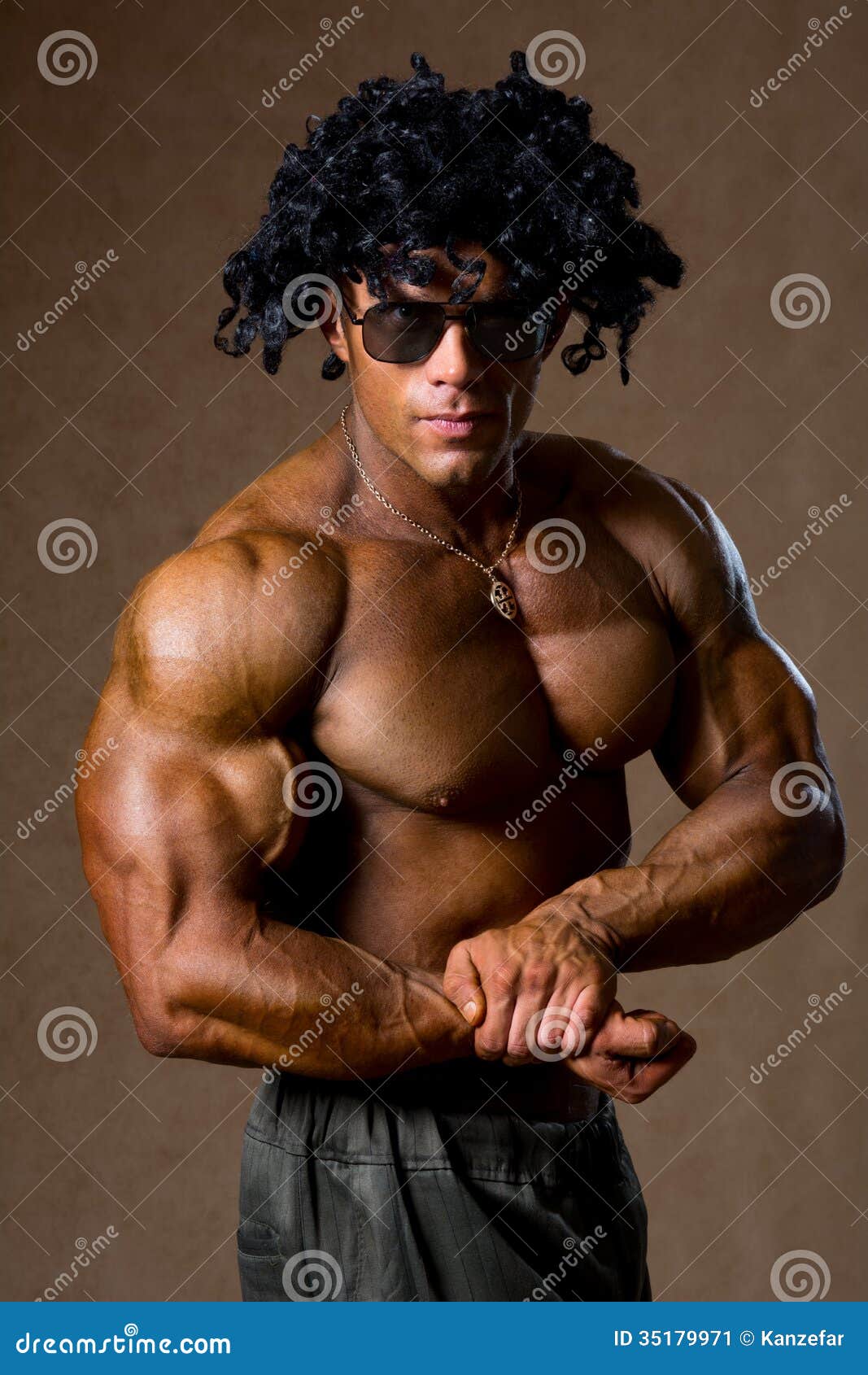Muscular Bodybuilder with Curly Hair Shows His Biceps Stock Image