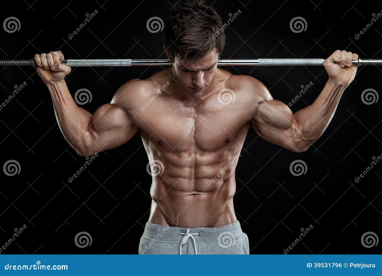 muscular bodybuilder guy doing exercises with dumbbell