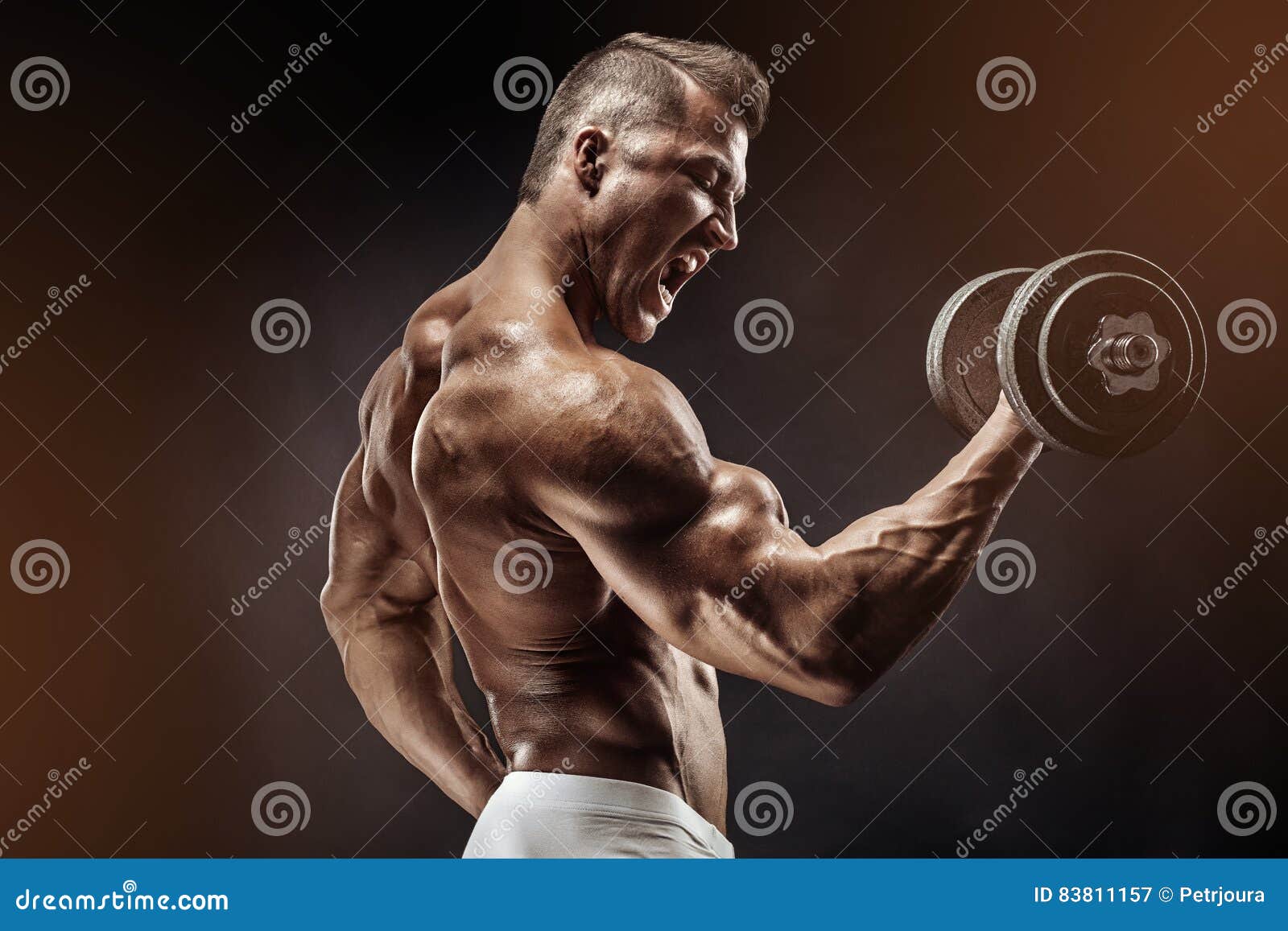muscular bodybuilder guy doing exercises with dumbbell