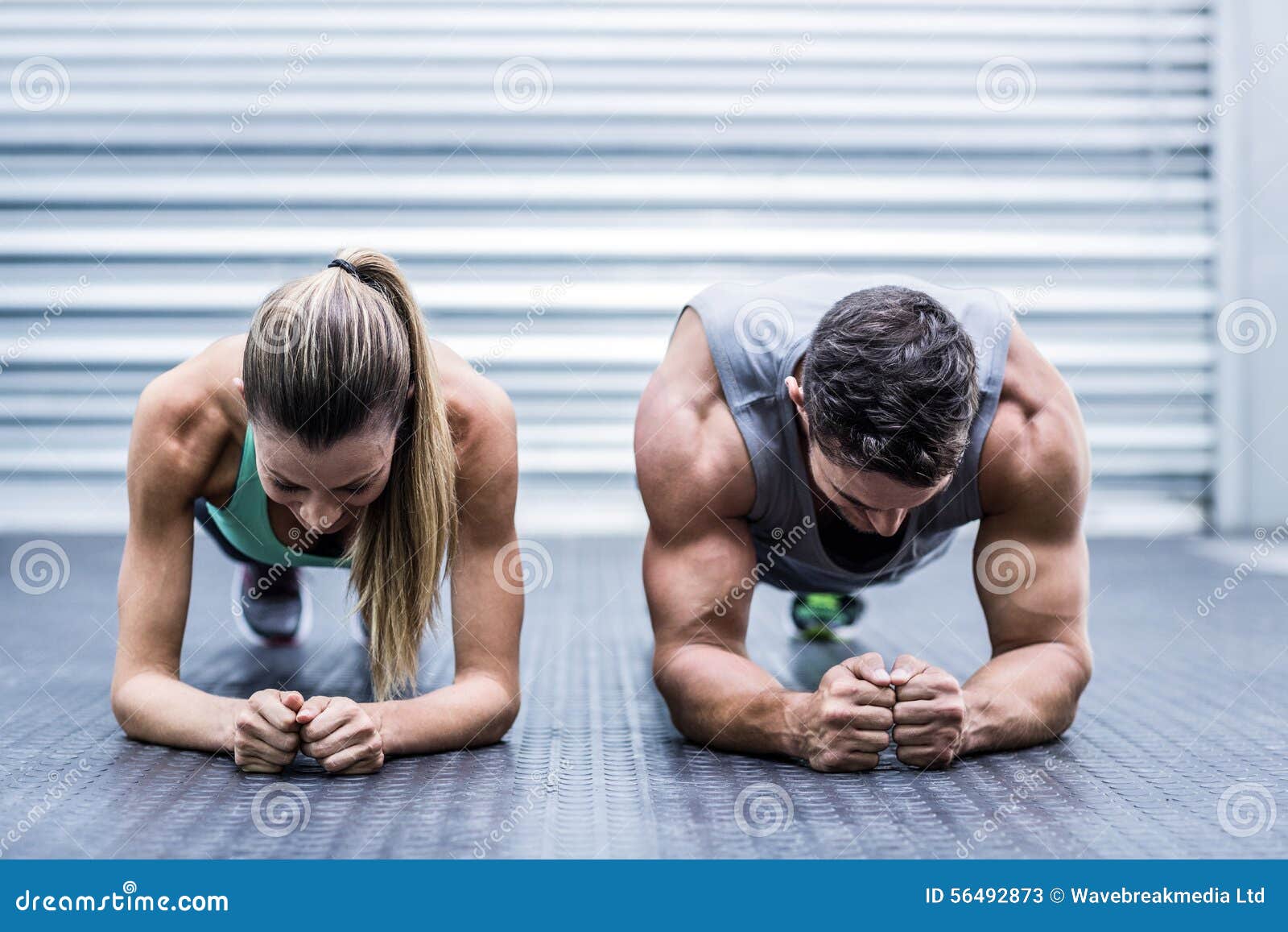 muscular couple doing planking exercises