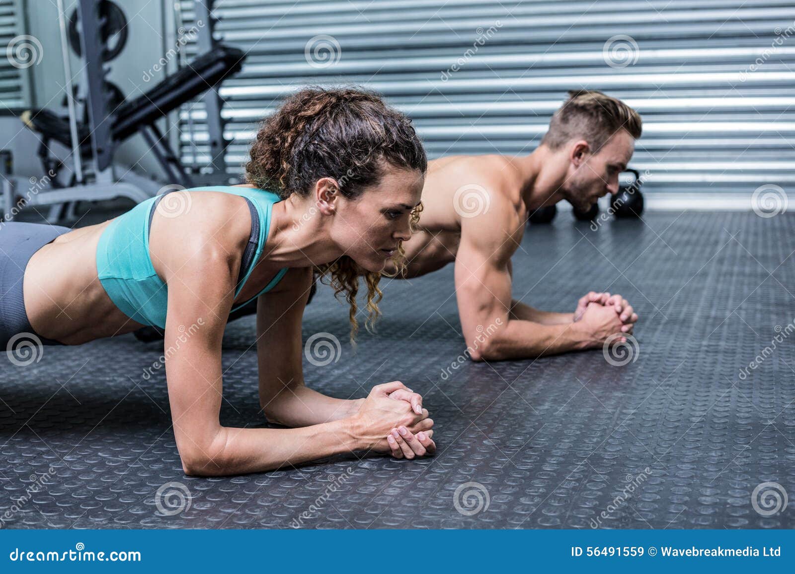 muscular couple doing planking exercises