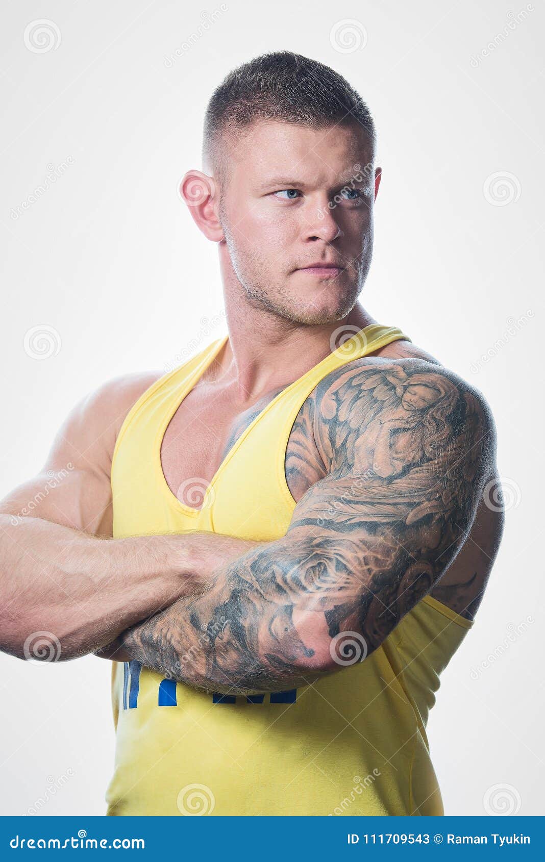Muscular Man with Blue Eyes and Tattoo in the Yellow Tank Top Looking Away on the White Background in a Gym Stock Image - Image of aesthetic, ripped: 111709543