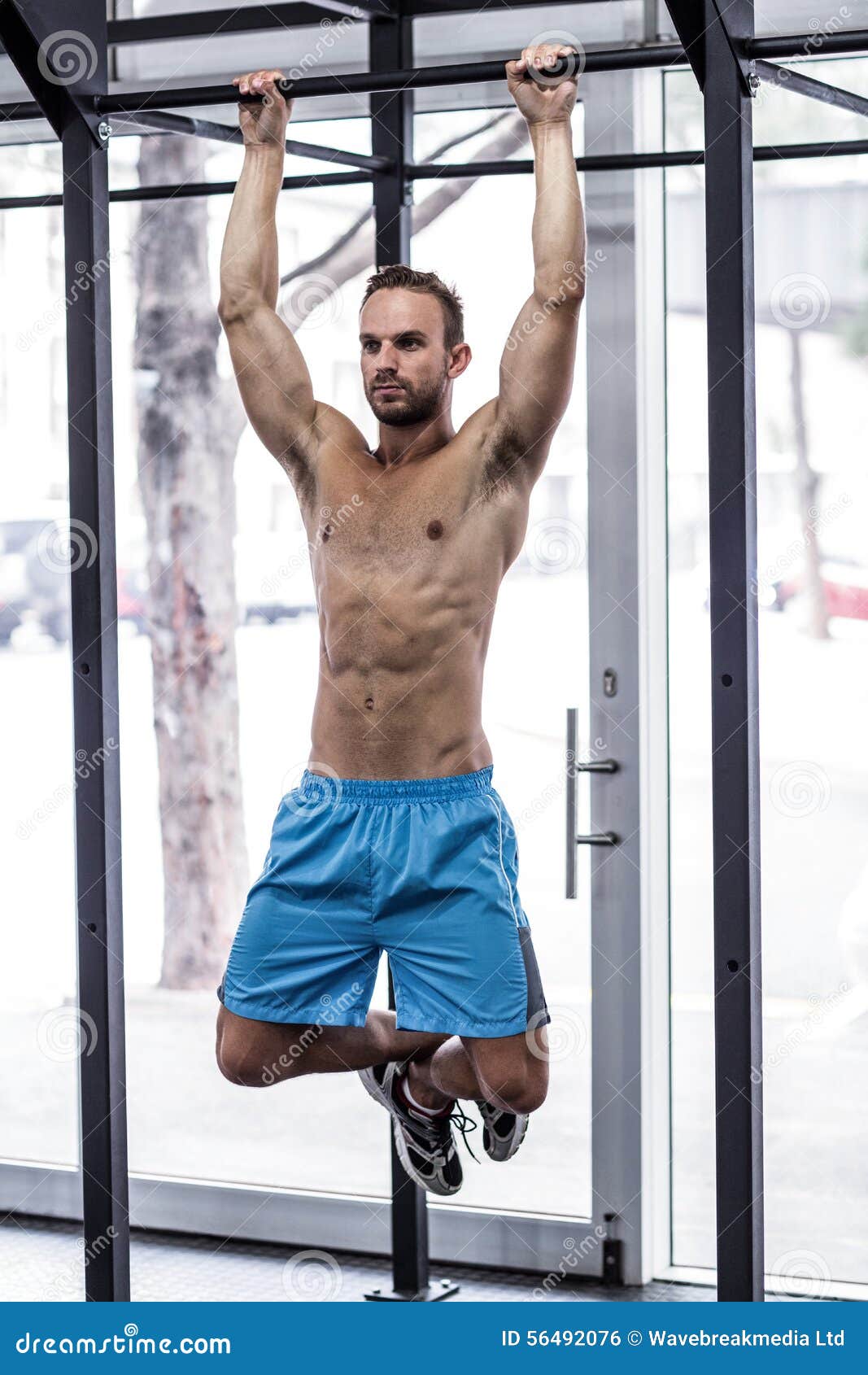 muscular man doing pull up exercises