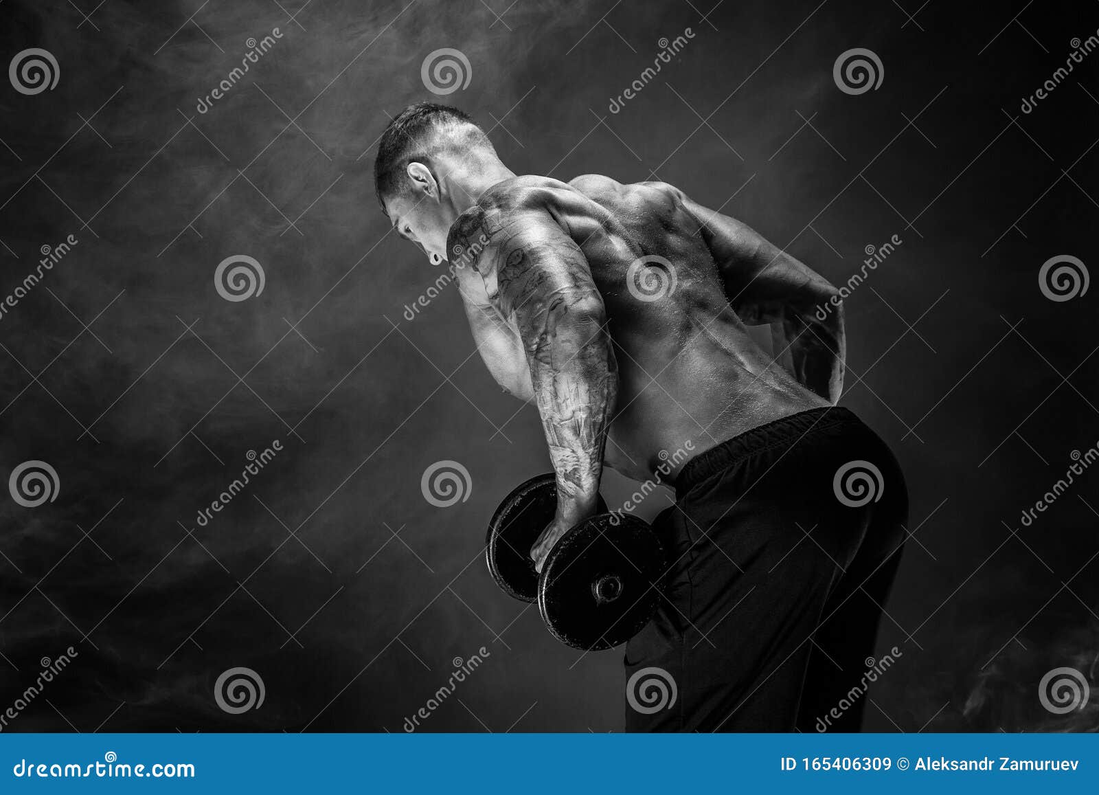 muscular man with dumbbells doing exercises. photo of strong male