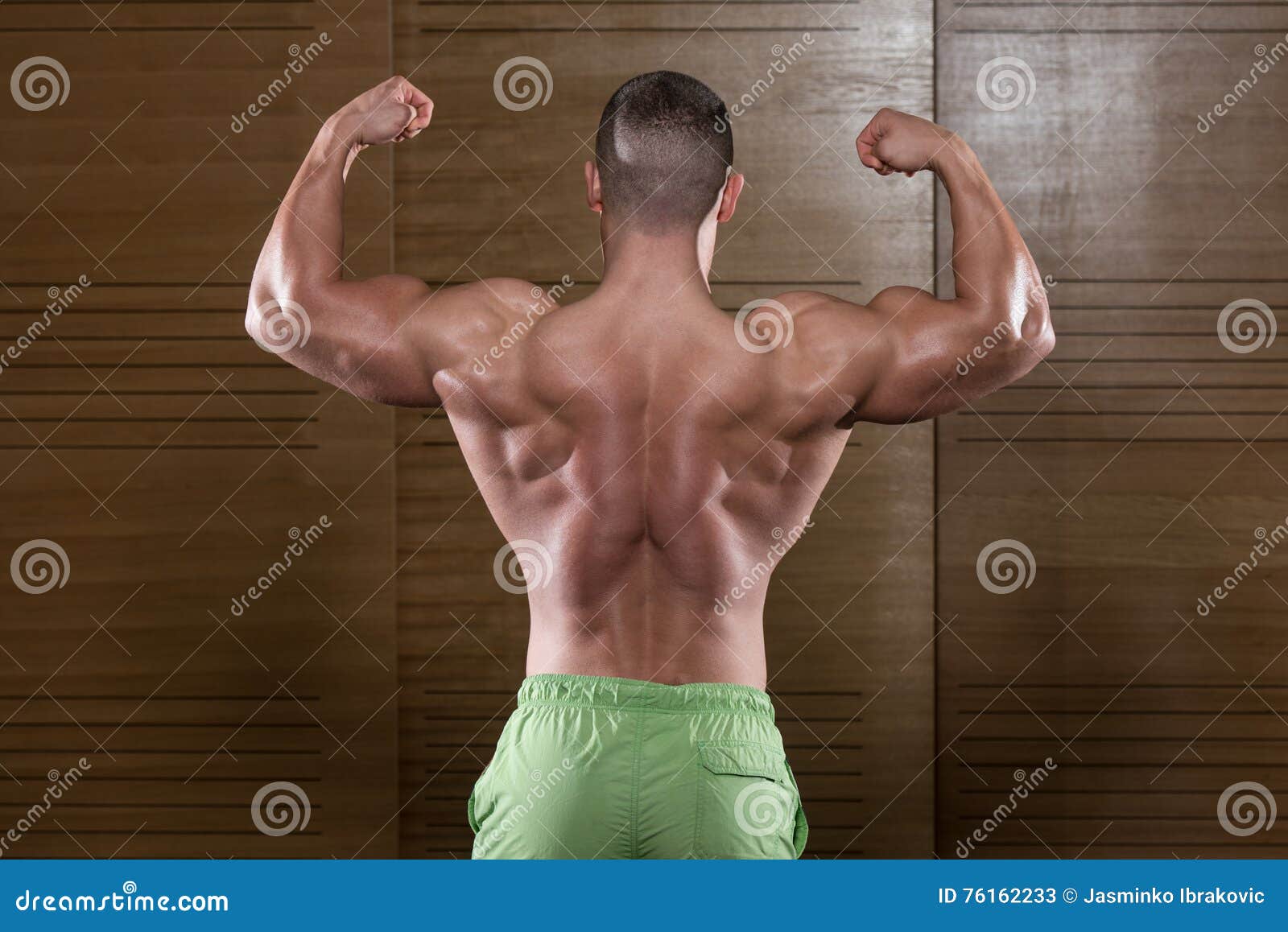 A muscular Caucasian man poses to emphasize his strong back and arms for  fitness content. from Pikwizard