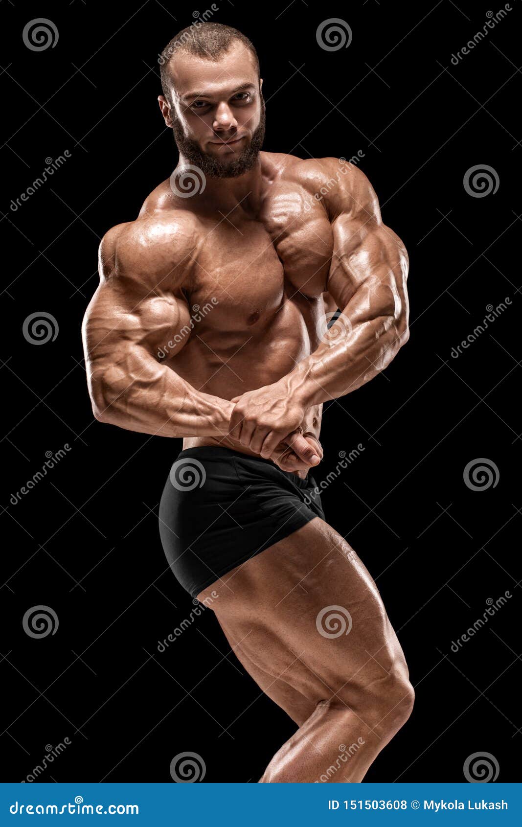 Muscular man showing muscles isolated on the black background. Strong male  naked torso abs Stock Photo