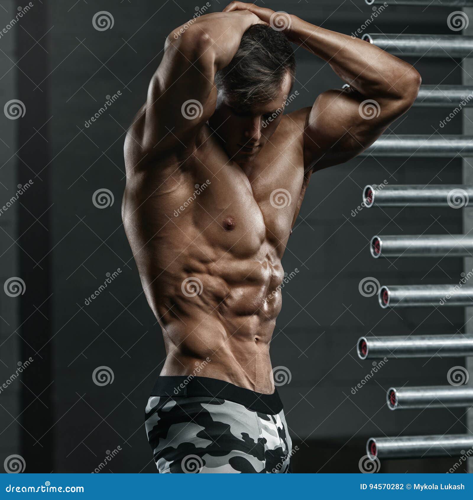 Muscular man showing muscles isolated on the black background. Strong male  naked torso abs Stock Photo