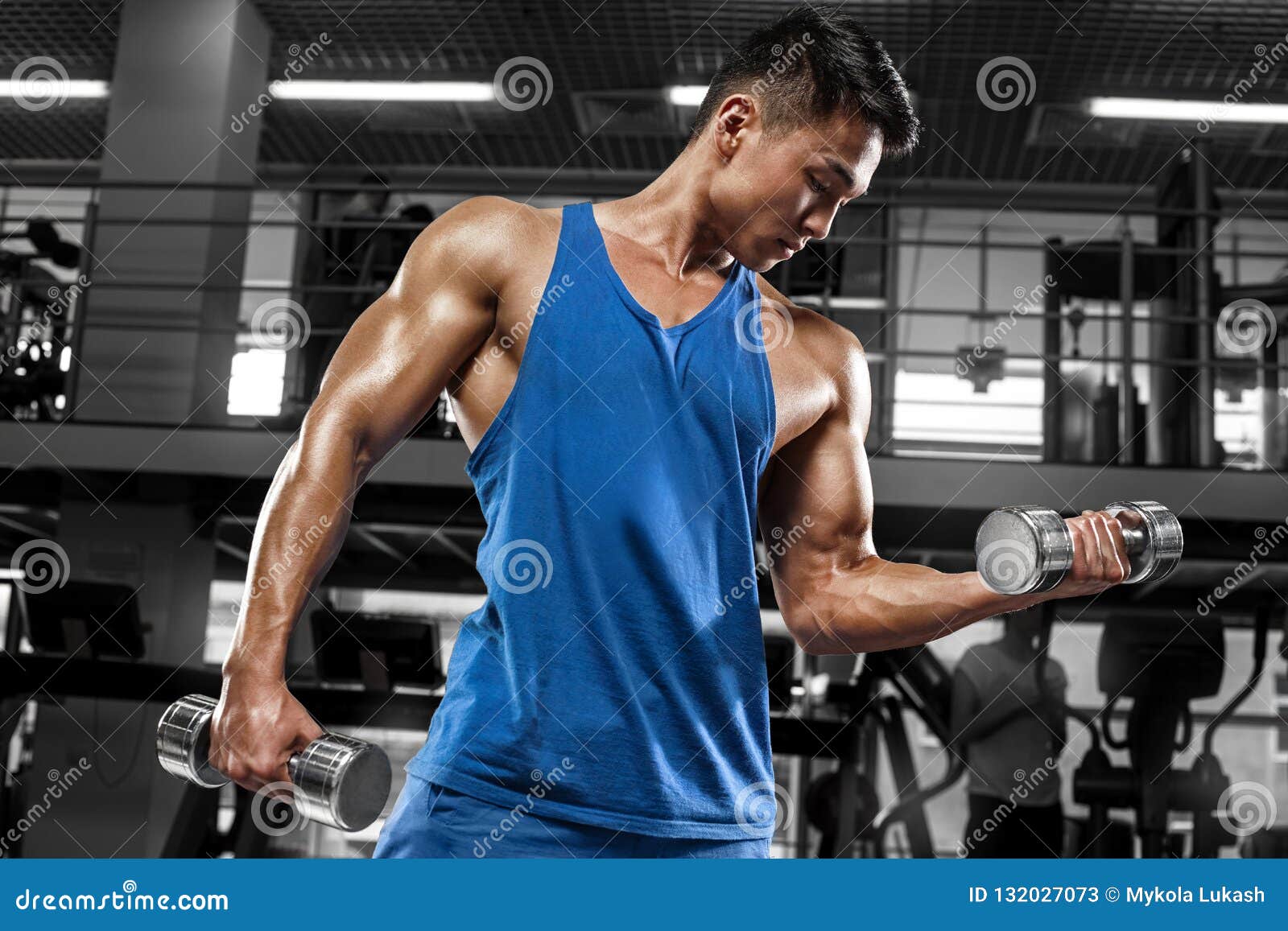 Muscular Bodybuilder Man Doing Exercises On A Biceps With 