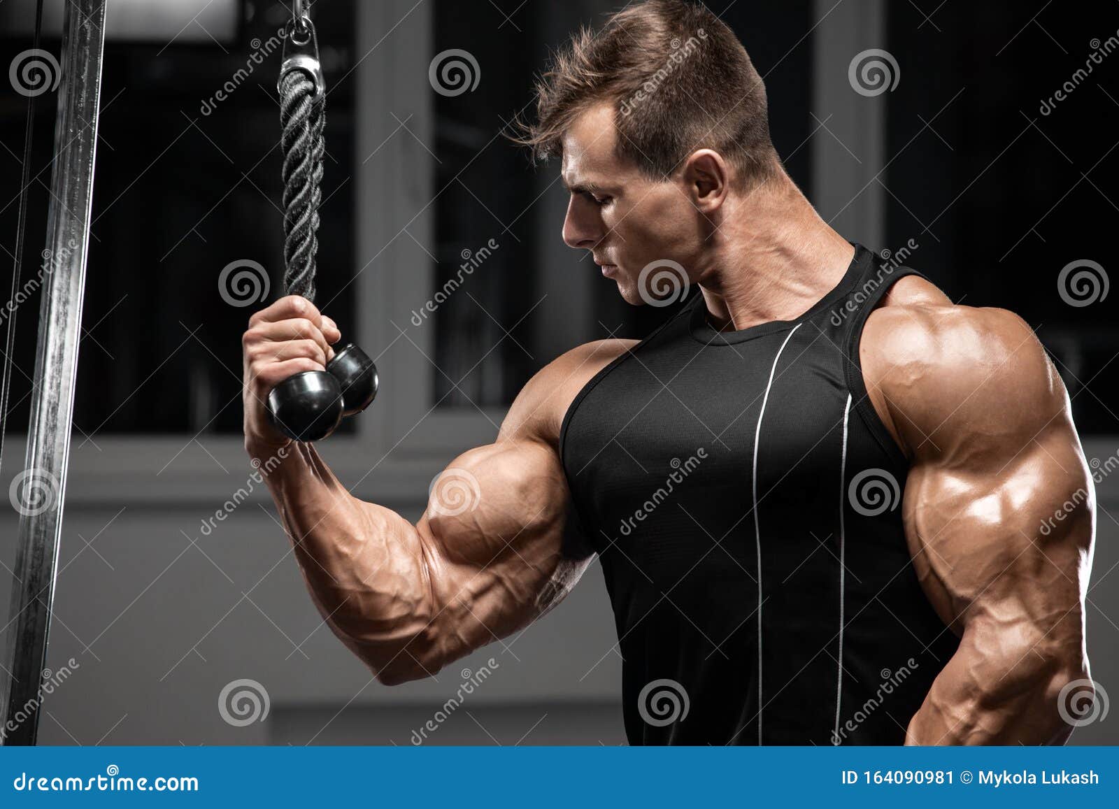 muscular man workout in gym doing exercises for biceps, strong bodybuilder male showing biceps