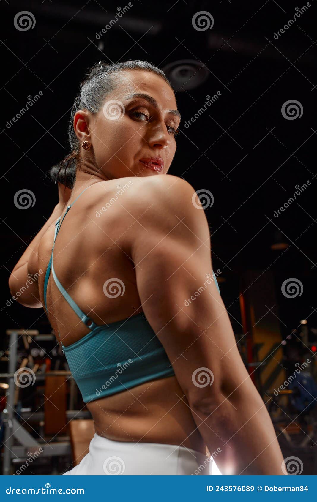Muscular Woman in Gym Showing Back Muscles. Strong Fitness Girl