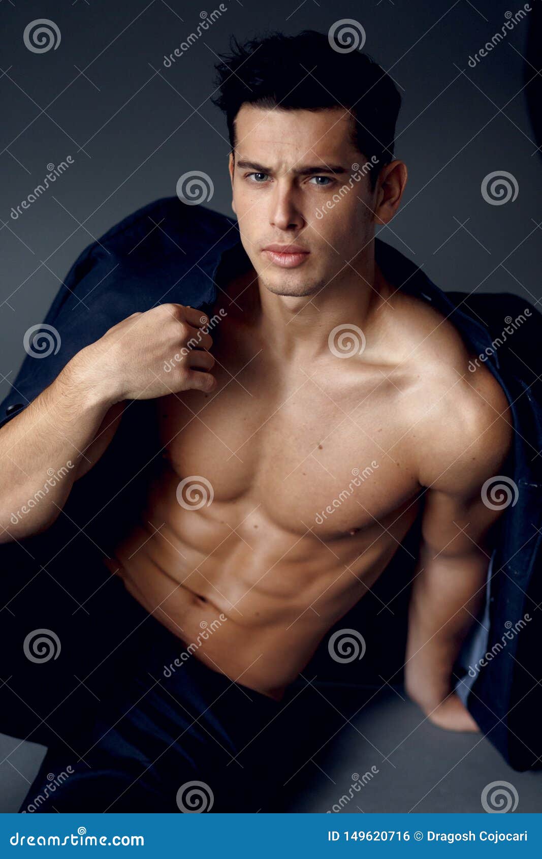Young muscular man with naked torso wearing a red hat and 