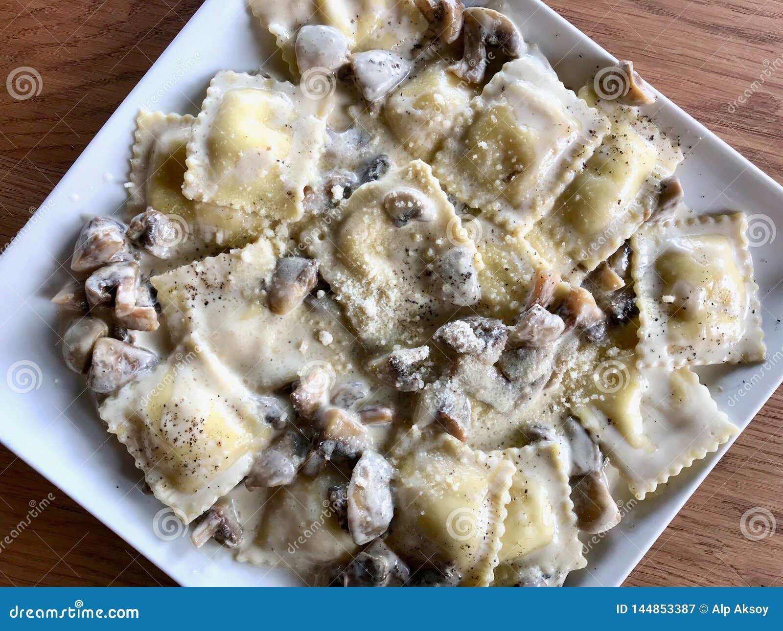 mushroom ravioli pasta with cream sauce in rectangular plate