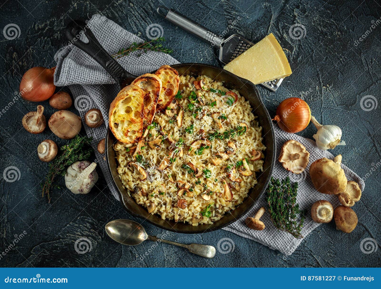 mushroom risotto in iron pan with herbs and parmesan cheese