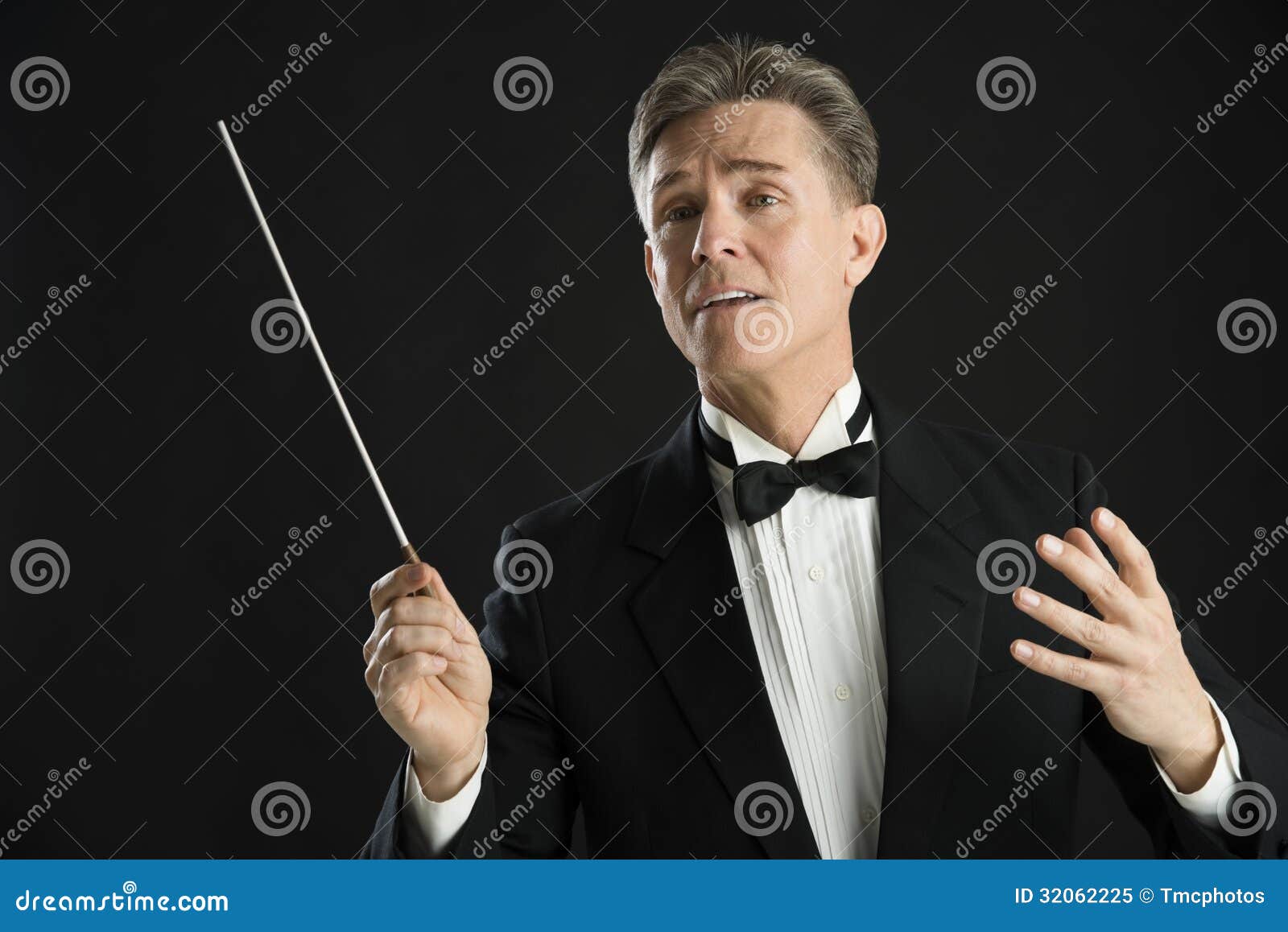 music conductor looking away while directing with his baton