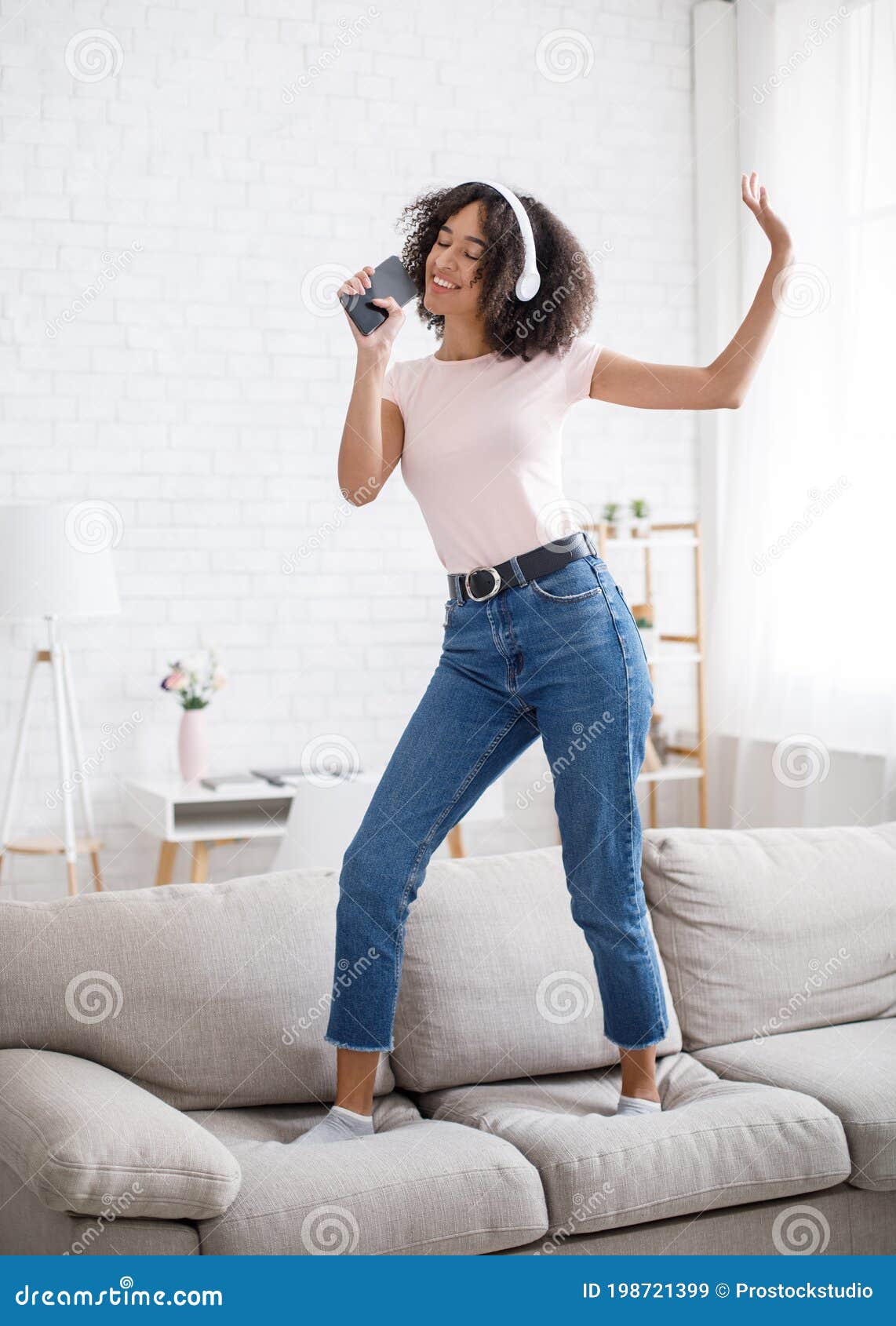 Musical Mobile App and Imaginary Microphone. Funny African American Woman  Dancing on Sofa Stock Image - Image of musical, microphone: 198721399