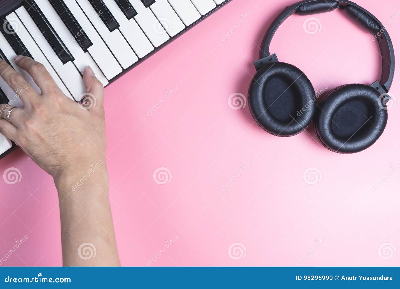 Musician is Playing on Keyboard with Studio Headphone on Pink Stock