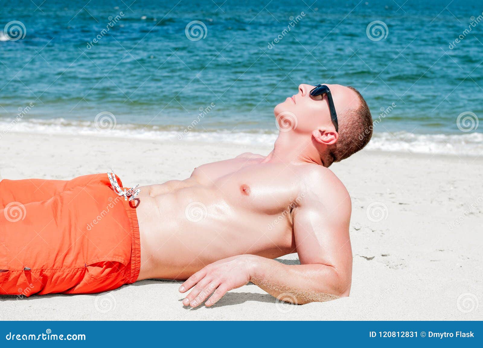 Гол пляж муж. Парень лежит на пляже. Лежа на пляже мужчина.