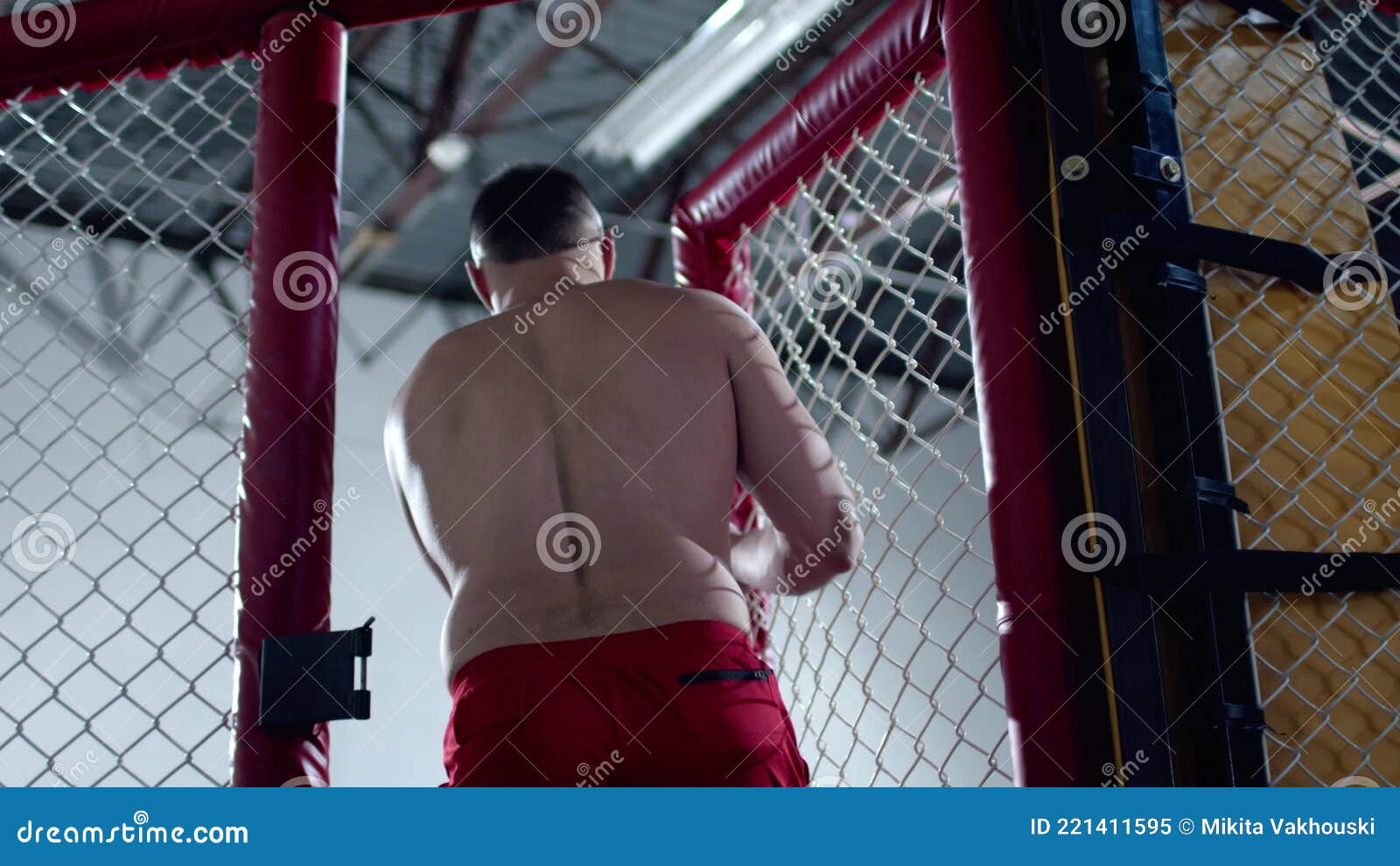Muskulöser MMA-Kämpfer Betritt Den Oktagon-Käfig Und Schließt Ihn