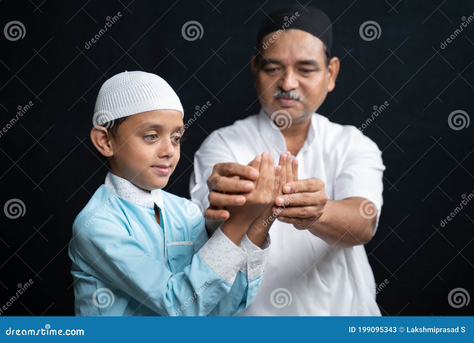muslim father teaching his son how to do salah or payer in a islamic way.