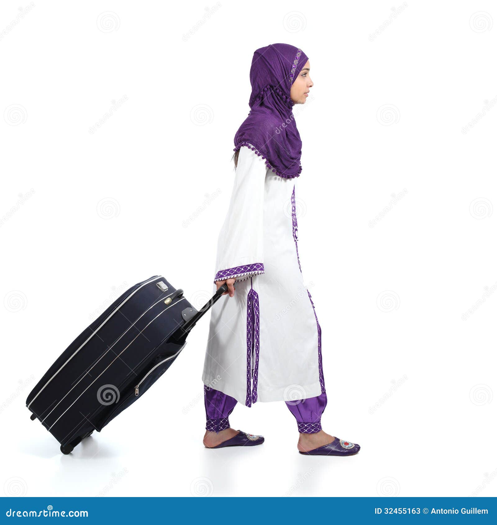 muslim immigrant woman wearing a hijab walking carrying a suitcase