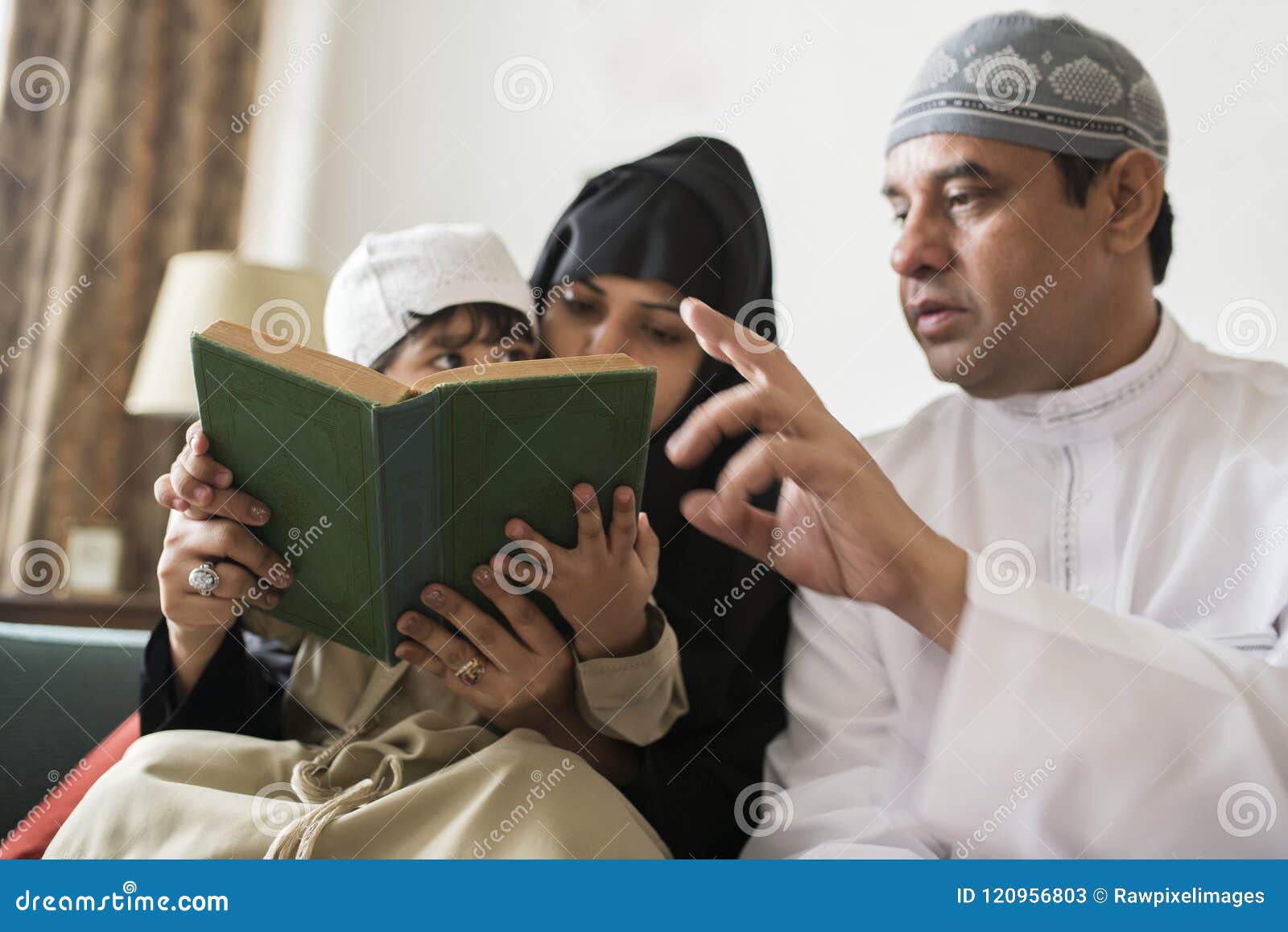 muslims family reading the quran together at home