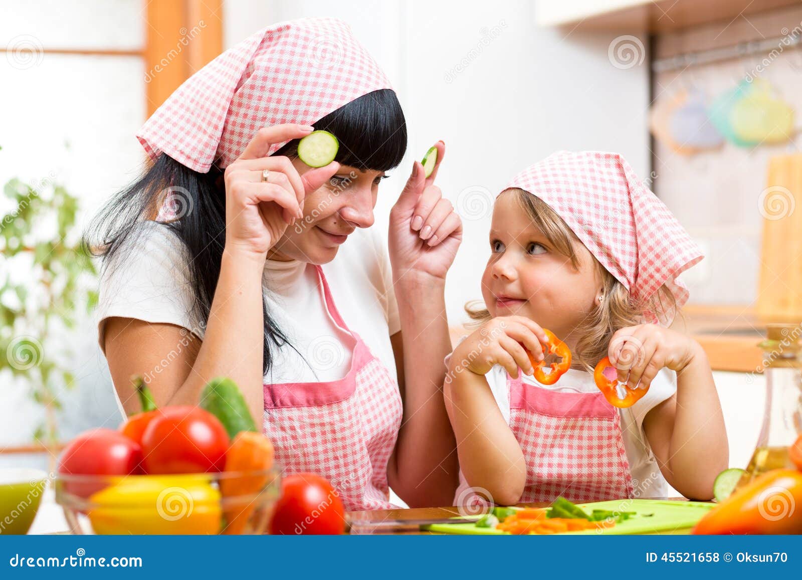 Mutter und Kind, die gesundes Lebensmittel zubereiten. Mutter- und Kindermädchen, das gesundes Lebensmittel zubereitet