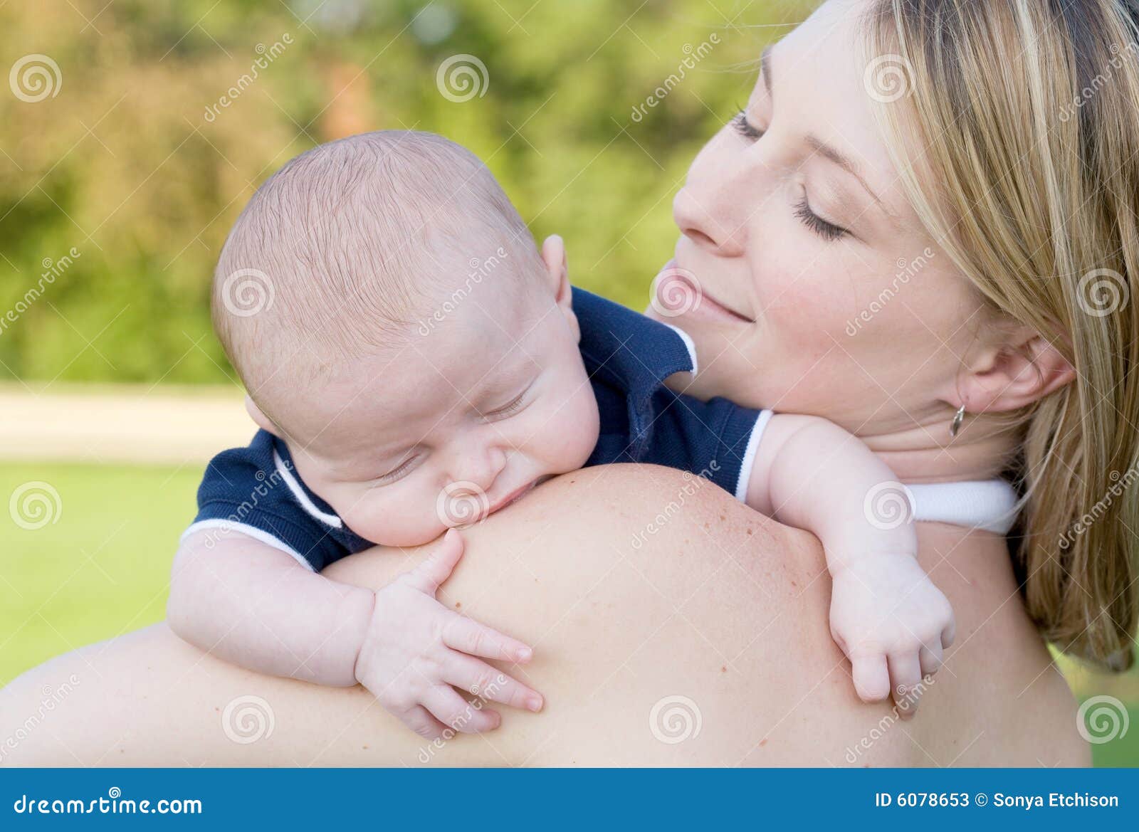 Mutter und Sohn. Mutter, die ihr Schätzchen überwachend zu schlafen lächelt