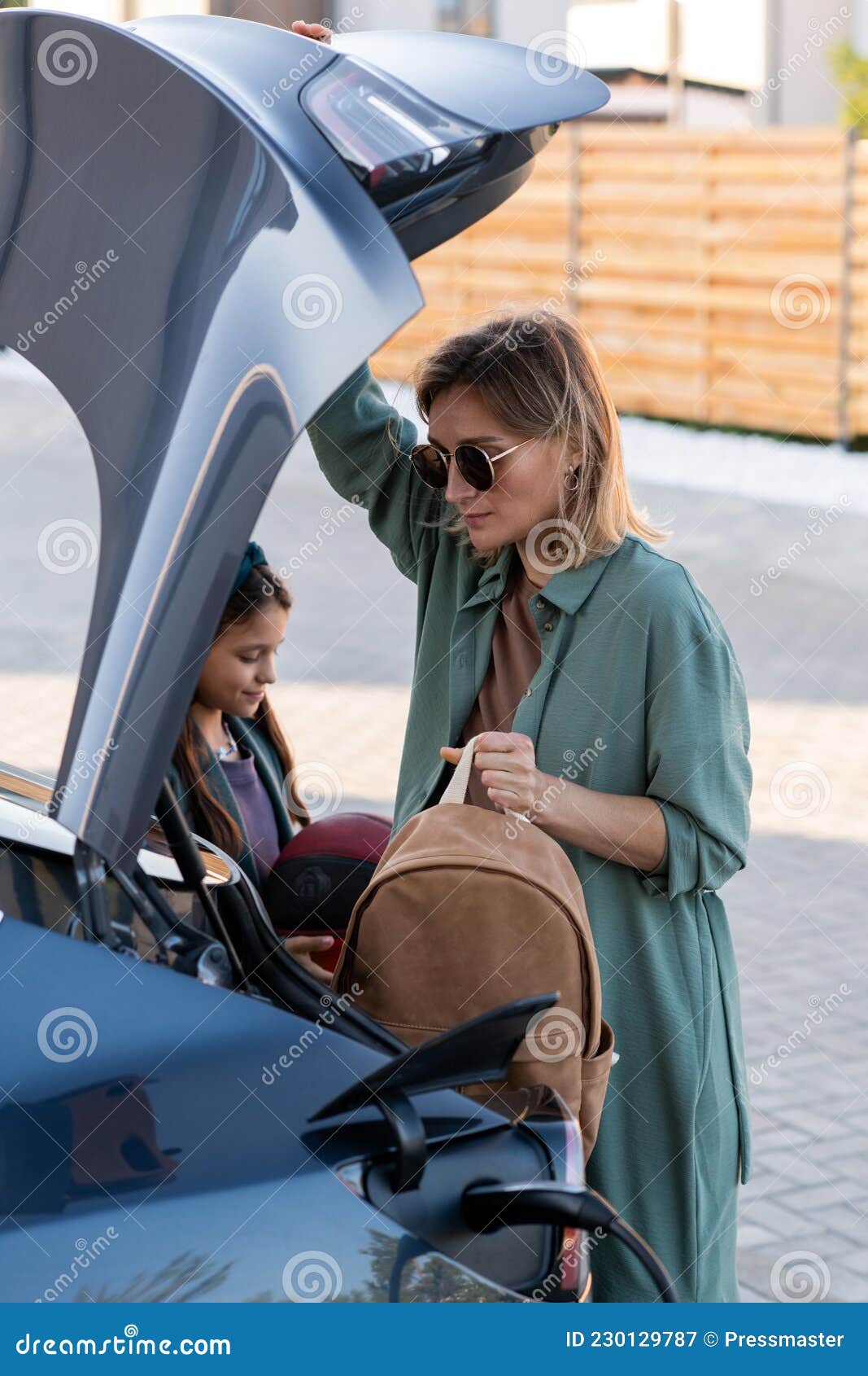 Mutter Und Tochter, Die Sachen Aus Dem Kofferraum Holen, Während Sie Das  Auto Aufladen Stockbild - Bild von seilzug, öko: 230129787