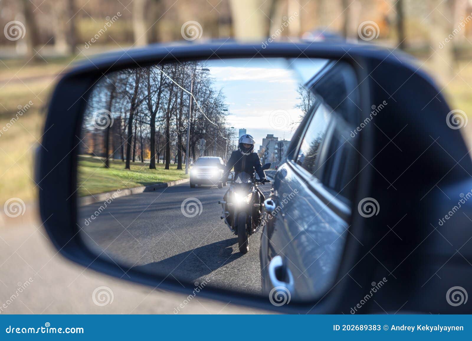 mutual passing, motorcycle and vehicle with dazzle lighting overtaking the car, view in a side mirror. improper driving or traffic
