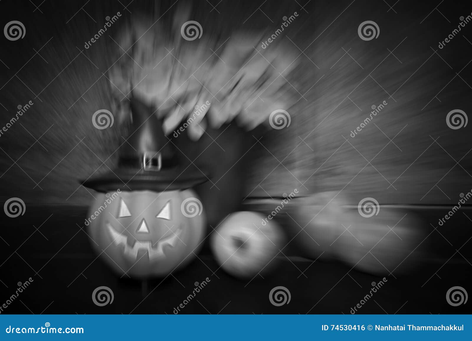 Muñeca y manzana de la calabaza en fondo de madera. Sistema de Halloween, de-enfocado y falta de definición del enfoque de la muñeca y de la manzana de la calabaza en el fondo de madera, ilustración negra, tono blanco y negro