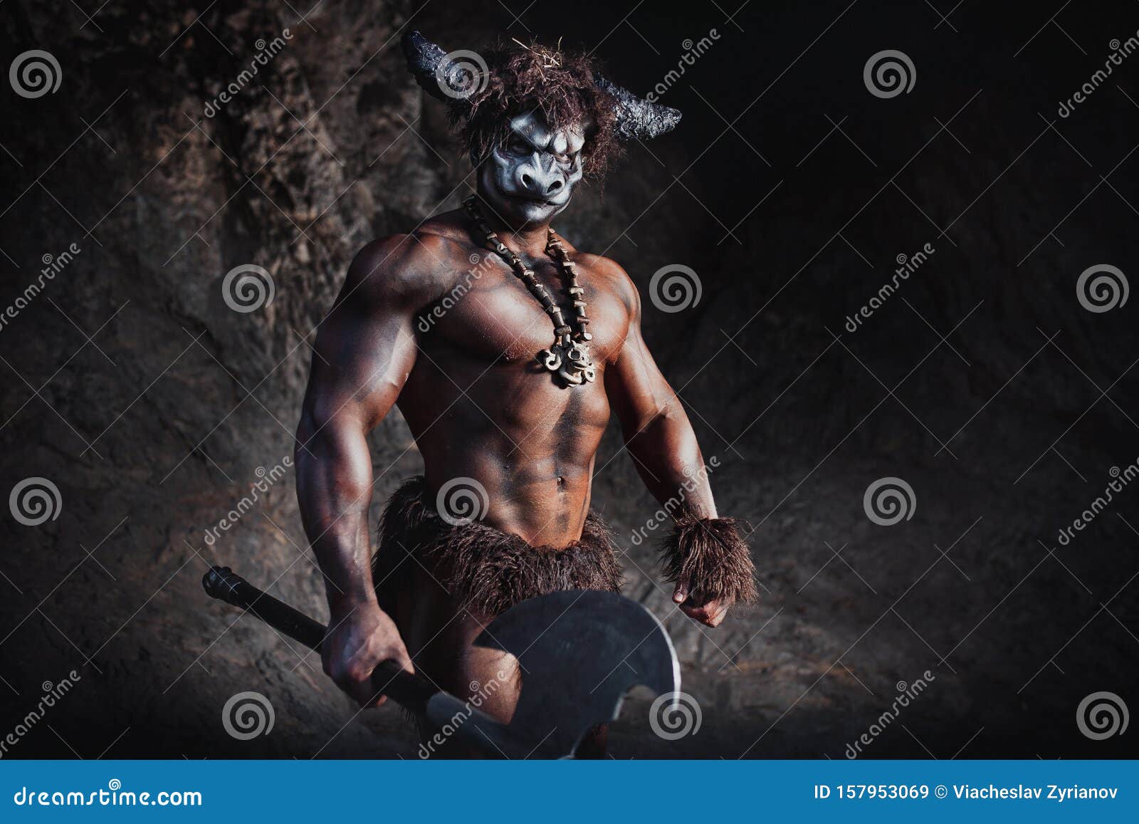 mythological minotaur  half bull half man stands in a rock cave in an aggressive stance