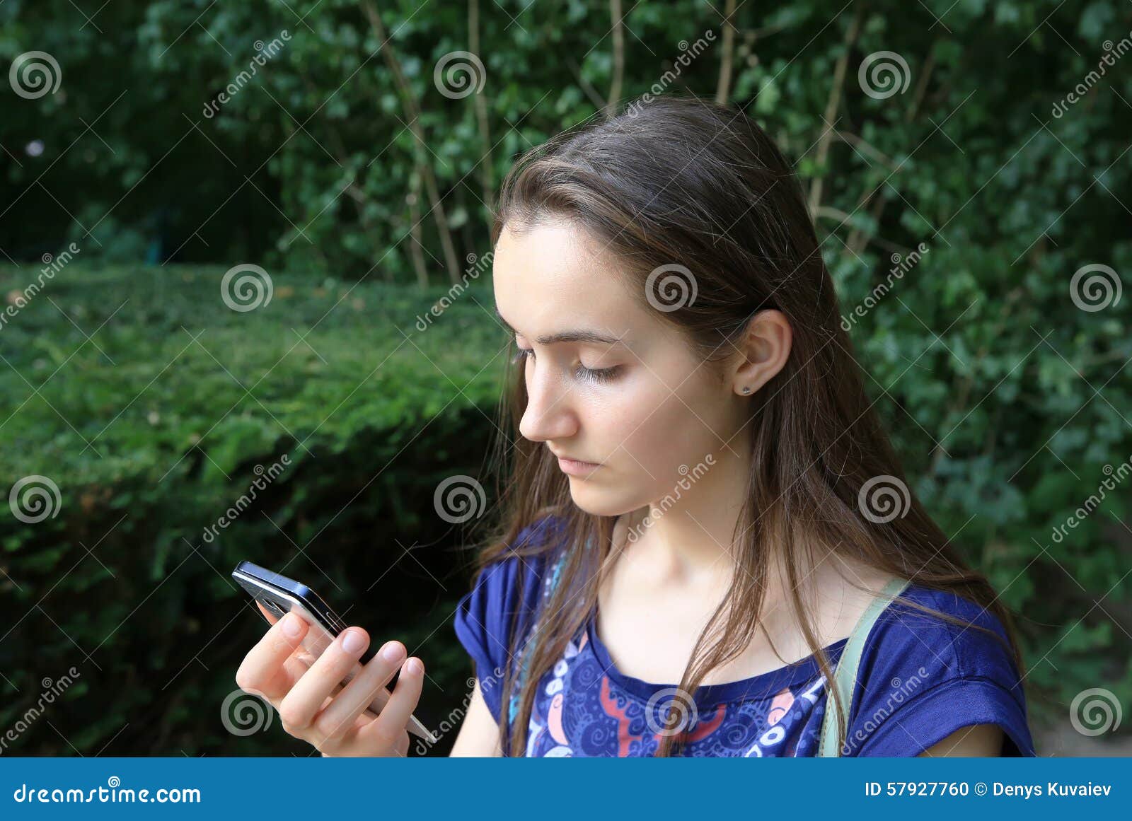 Mädchen mit einem Handy liest die Mitteilung im Park