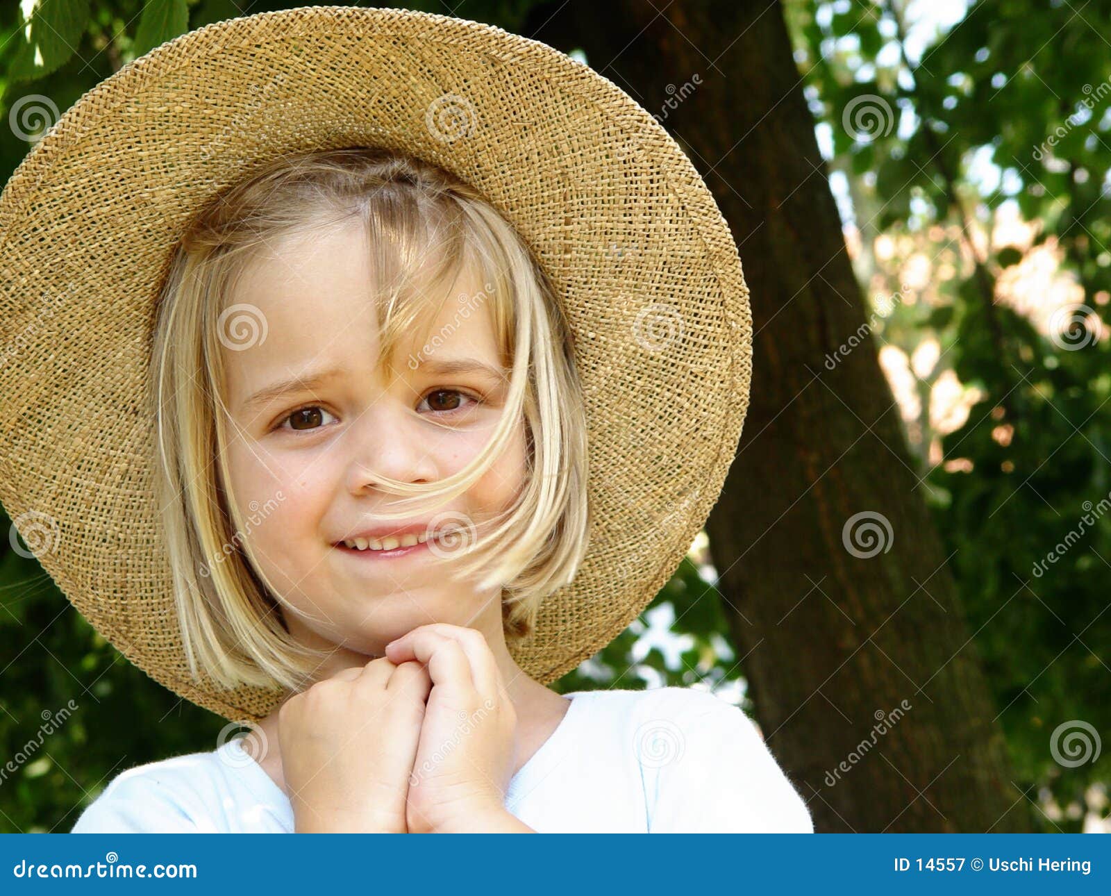 Mädchen mit Strohhut. Portrait eines 6 Einjahresmädchens mit Strohhut unter einem Baum