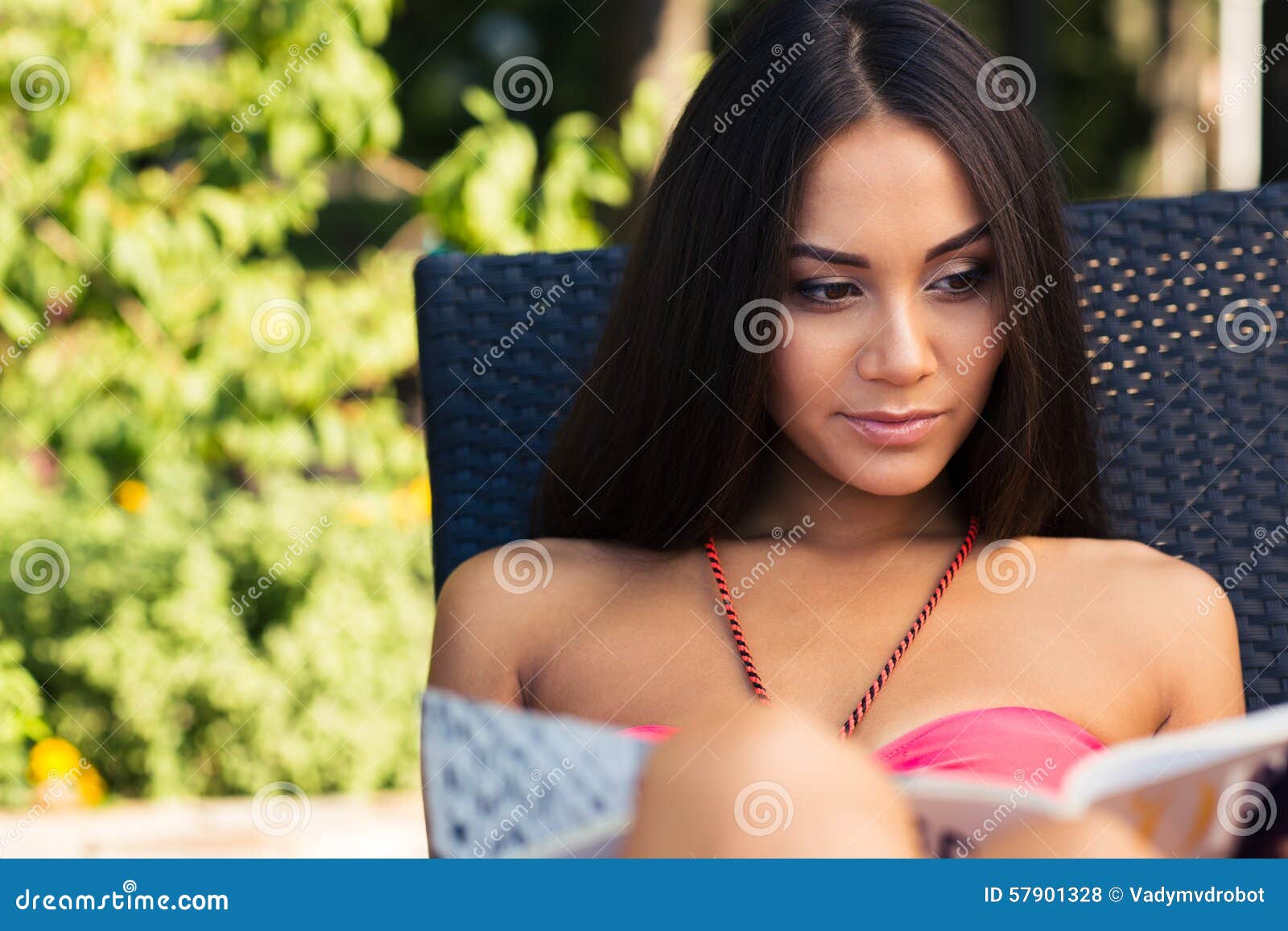 Reizend Mädchenlesezeitschrift auf dem deckchair draußen
