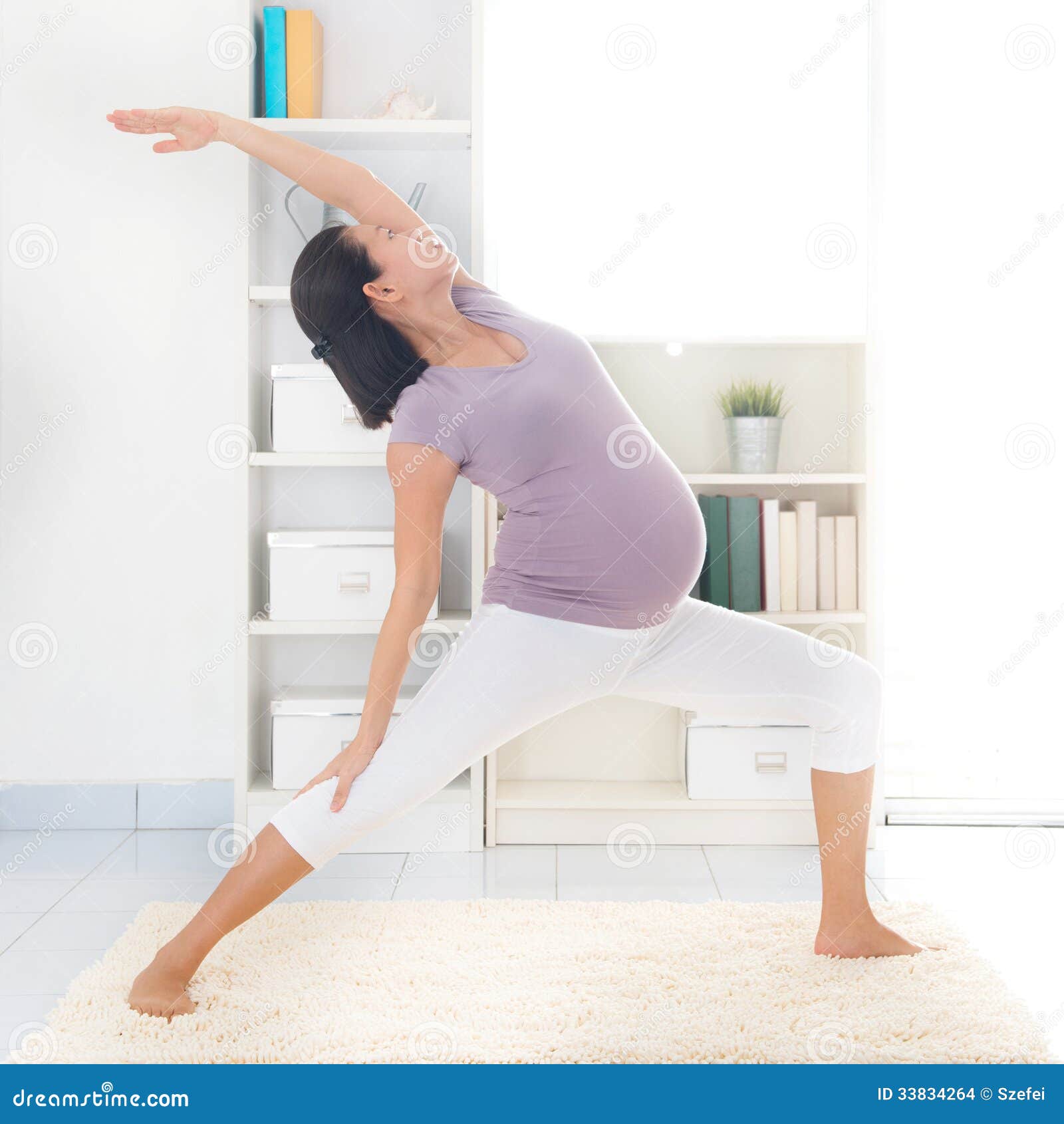 Mütterliches Yoga. Pränatale Yogaklasse. Gesunde 8 Monate in voller Länge schwangere ruhige Asiatin, die Yoga meditieren oder tun, trainieren zu Hause. Entspannung und Ausdehnen.