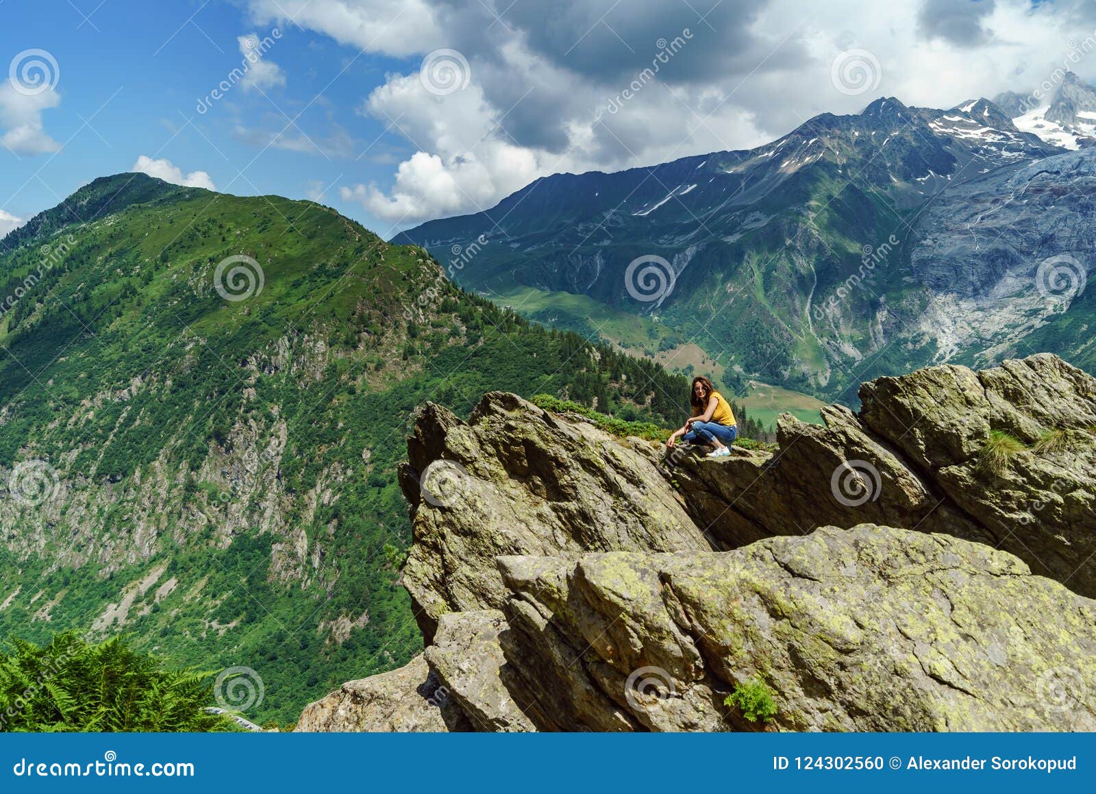 Młoda nastoletnia dziewczyna pozuje na dużym kamieniu w Alps, Francja