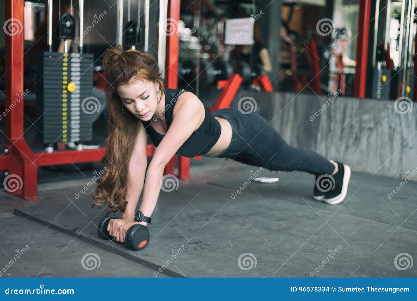 Młodej sprawności fizycznej kobiety azjatykci ćwiczenie i robić deski pozyci z dumbbells