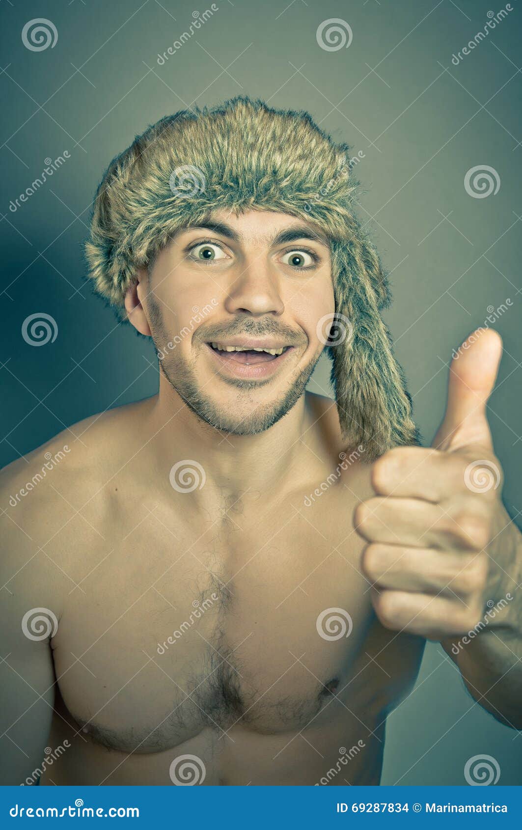 Młody sportive przystojny mężczyzna w eleganckiego modnisia futerkowym kapeluszu z szalonymi emocjami ono zgadza się i ono uśmiecha się, przedstawienia gesta OK Rocznika stonowany foto