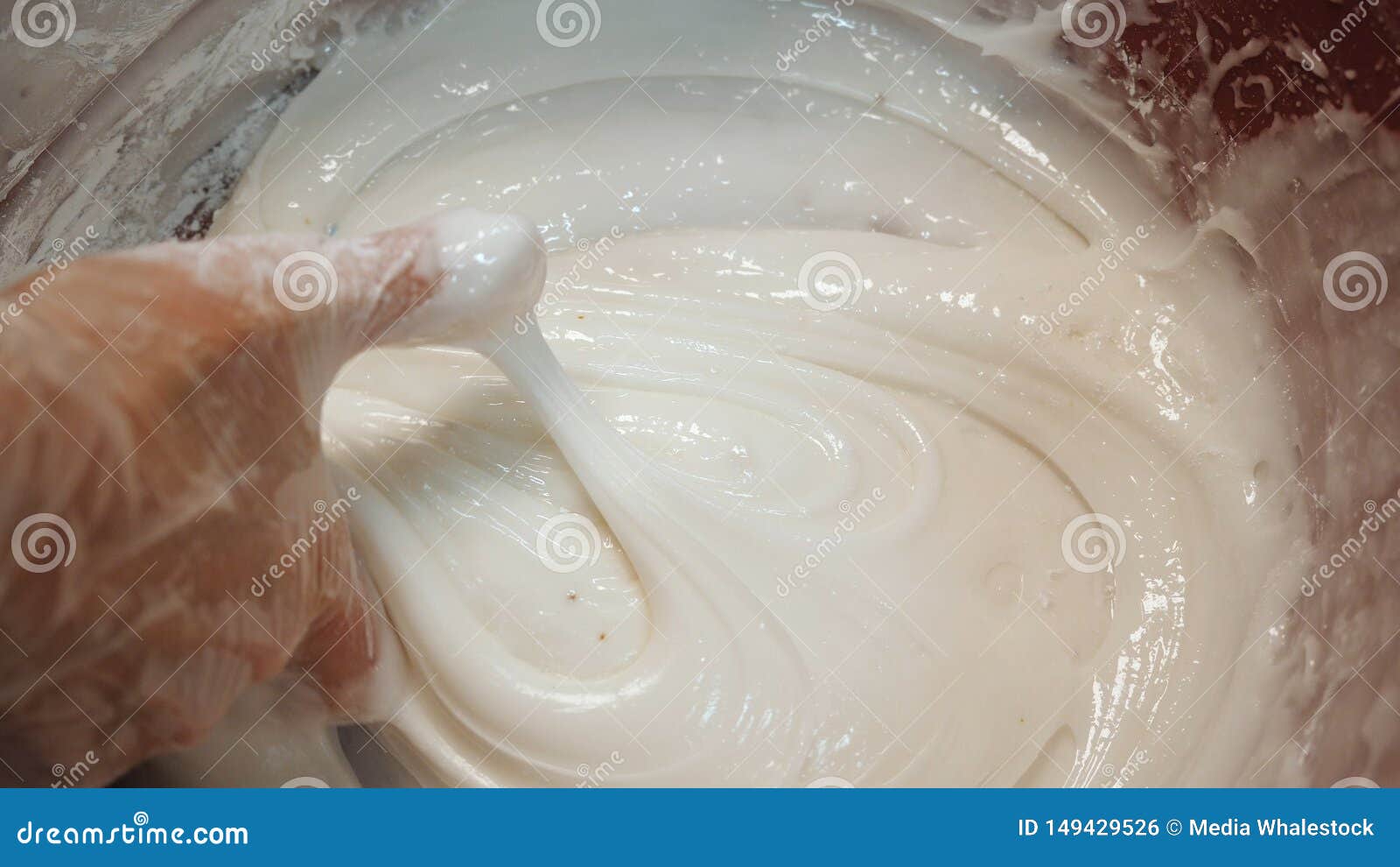 Close-up of Baker`s Hand in Silicone Gloves Mixing White Egg Cream for ...