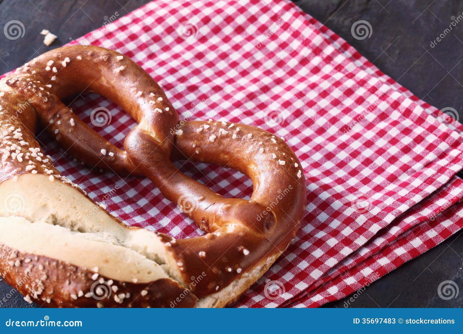 Nahaufnahme einer traditionellen selbst gemachten deutschen Brezel, auf einem karierten roten und weißen Geschirrtuch