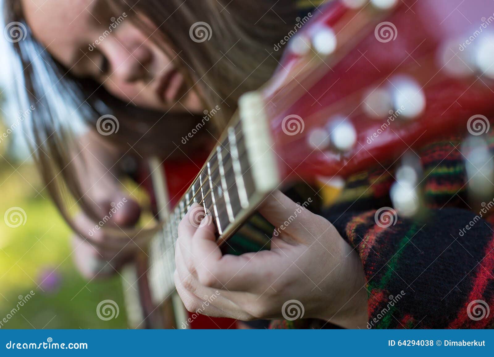 Nahaufnahme von Händen eines jungen Mädchens, das Akustikgitarre spielt liebhaberei