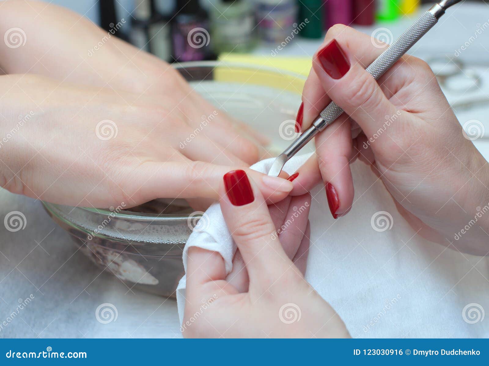 nail technician cuts the cuticles on the hands in the beauty salon.