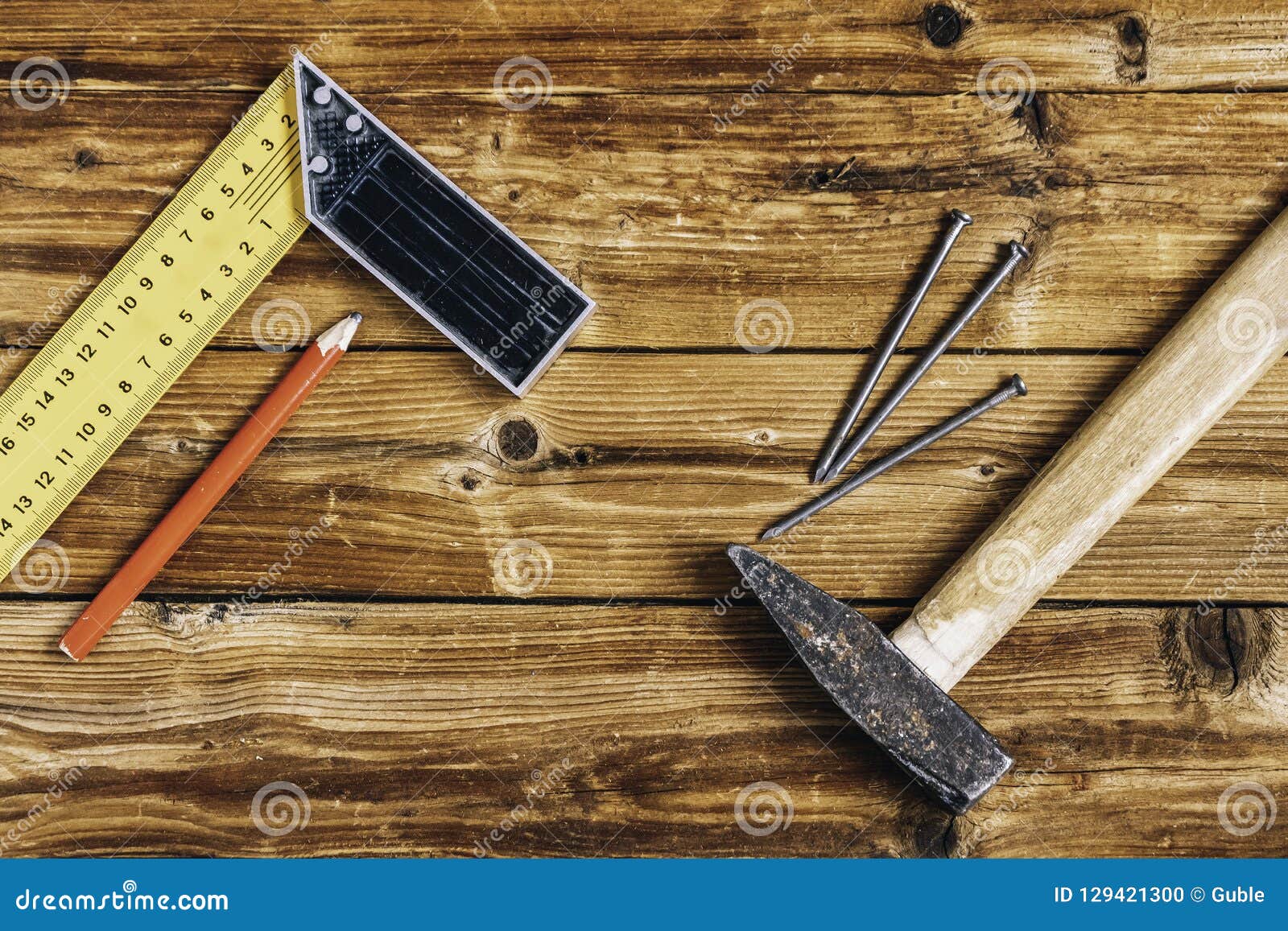 Nails, Old Hammer, Pencil and Measuring Angle on Wooden Background