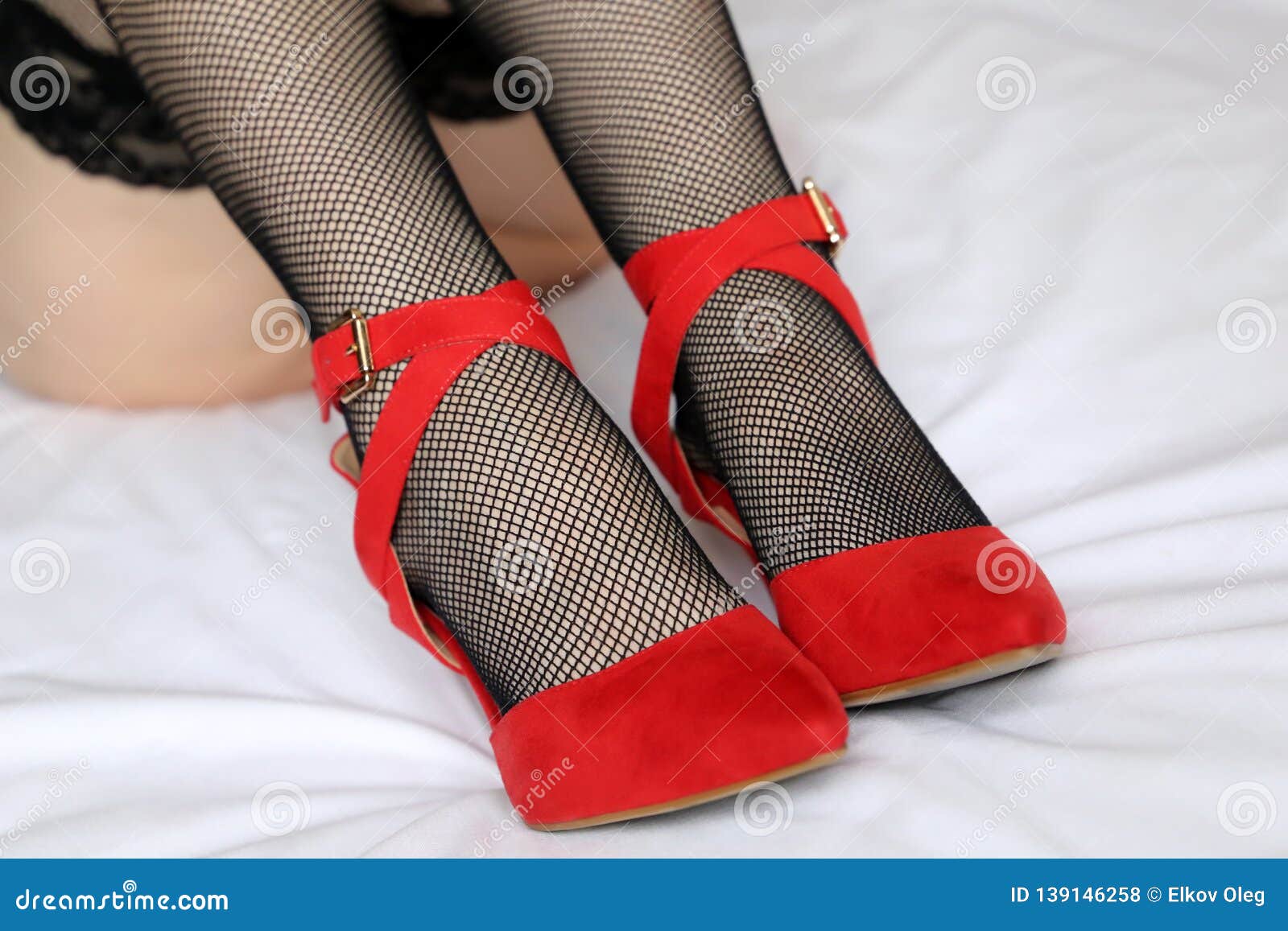 Female Legs in Black Fishnet Stockings and Red Shoes on High Heels Stock Photo pic picture