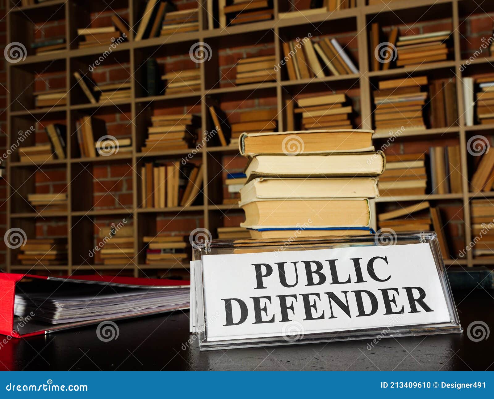 nameplate public defender and stack of book.