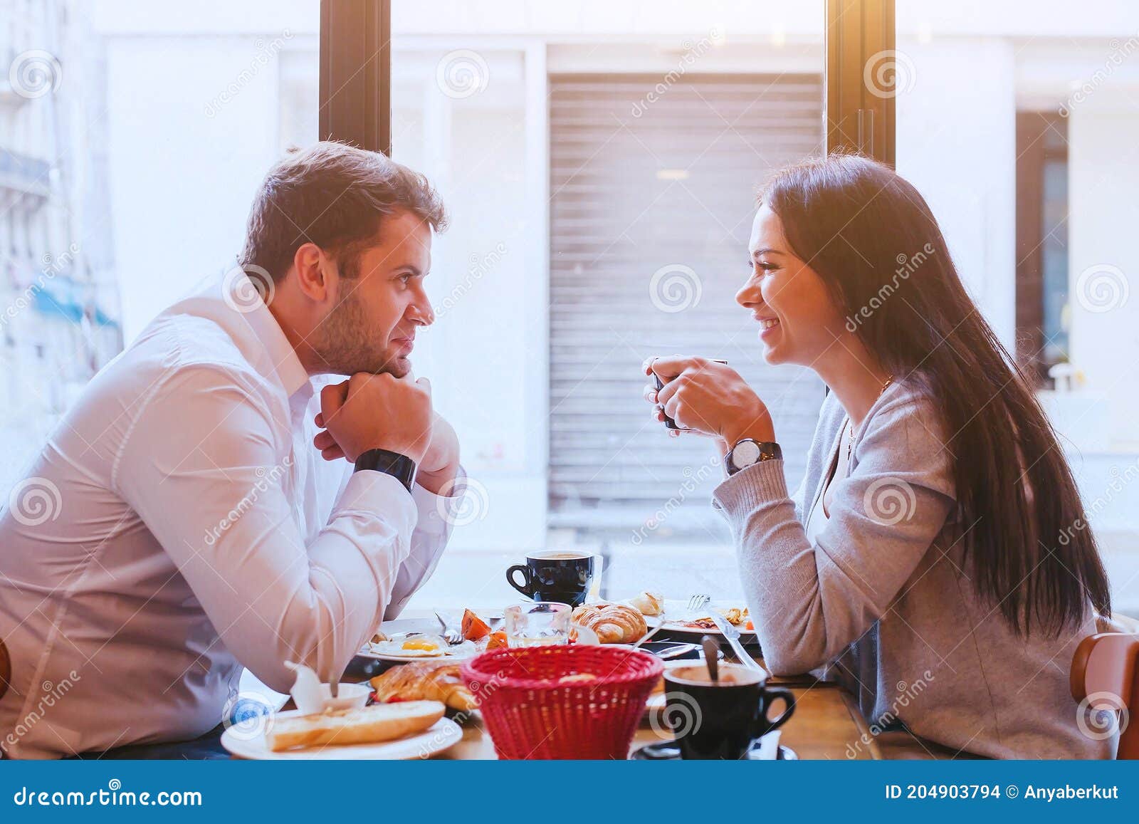 Namoro Casal, Nova York, Manhattan, Times Square Namoro Bebendo Café  Sorrindo Feliz Sentado Em Mesas Vermelhas Desfrutando De Suas Viagens De  Férias De Turismo Nos Eua. Mulher Asiática, Homem Caucasiano. Foto Royalty