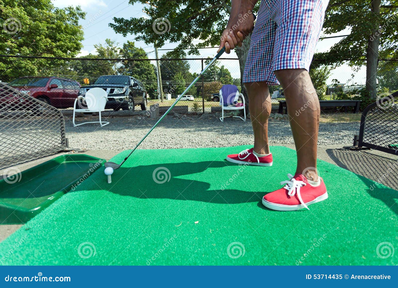 Napędowego pasma golfa praktyka. Sportowy golfisty chlanie przy napędowym pasmem ubierał w przypadkowym ubiorze