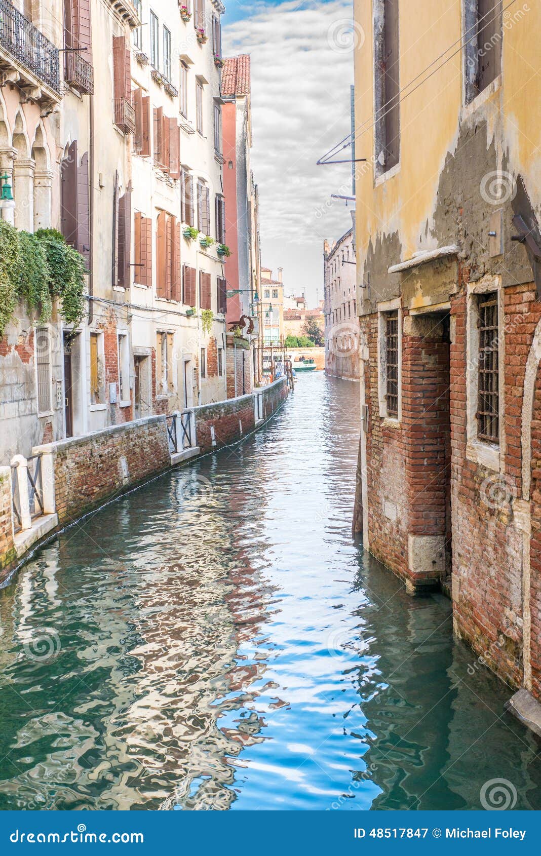 No parked boats on a narrow canal between houses on the island of Venice, Italy.